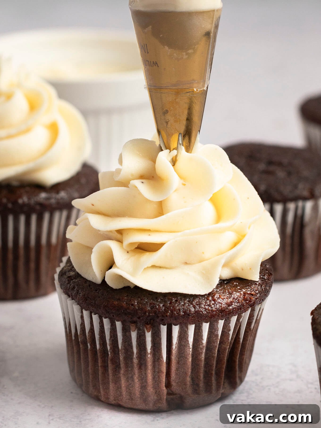 Caramelized Buttercream Dream 11 A chocolate cupcake receiving a swirl of brown butter frosting piped on top, showcasing its perfect piping consistency.