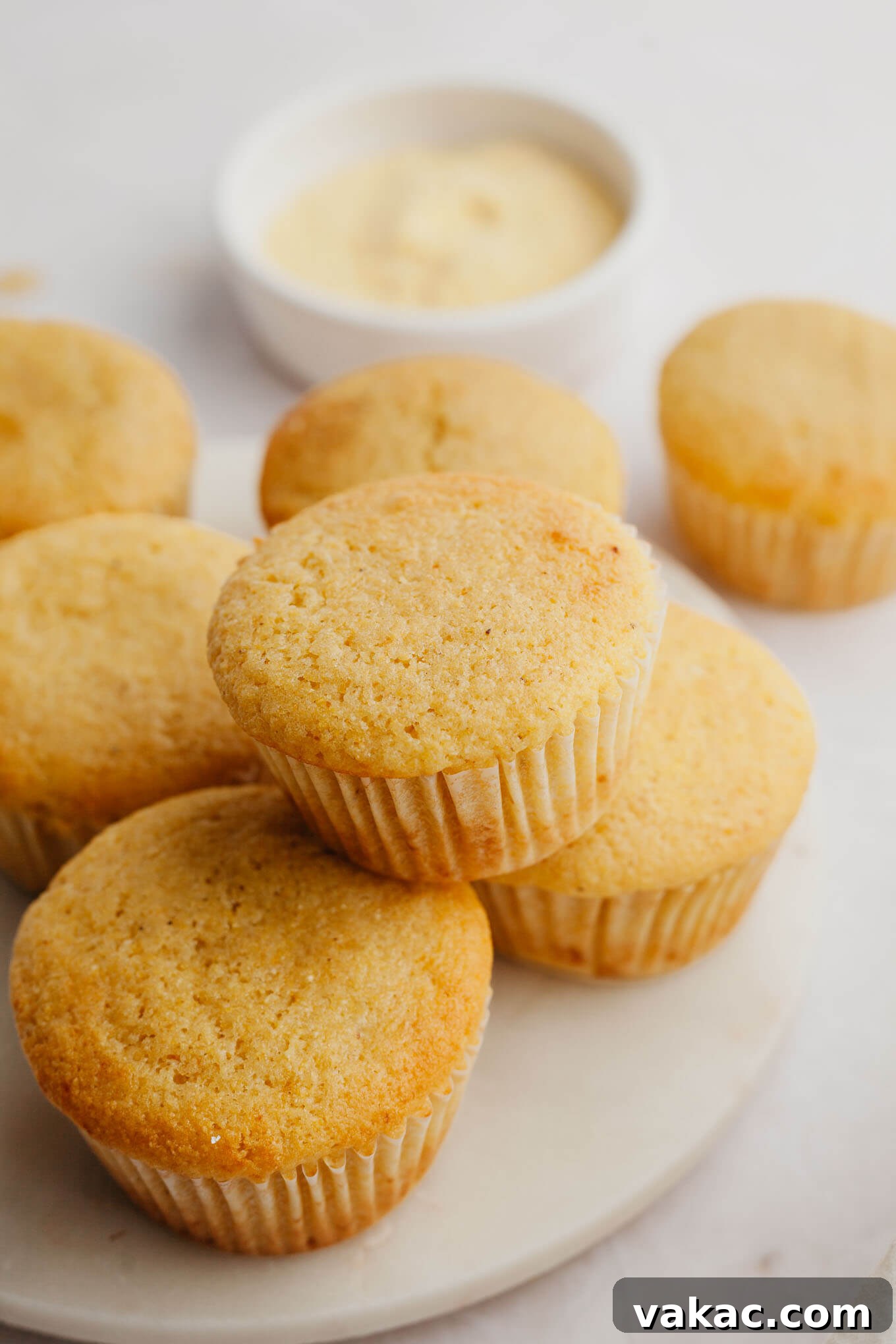 Golden Fluffy Cornbread Muffins 6 A beautiful marble serving platter featuring several freshly baked cornbread muffins, ready to be presented.