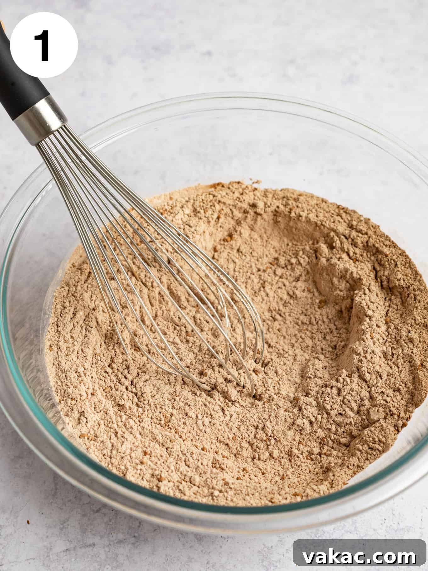 A glass mixing bowl containing the perfectly combined dry ingredients for the chocolate cookies.