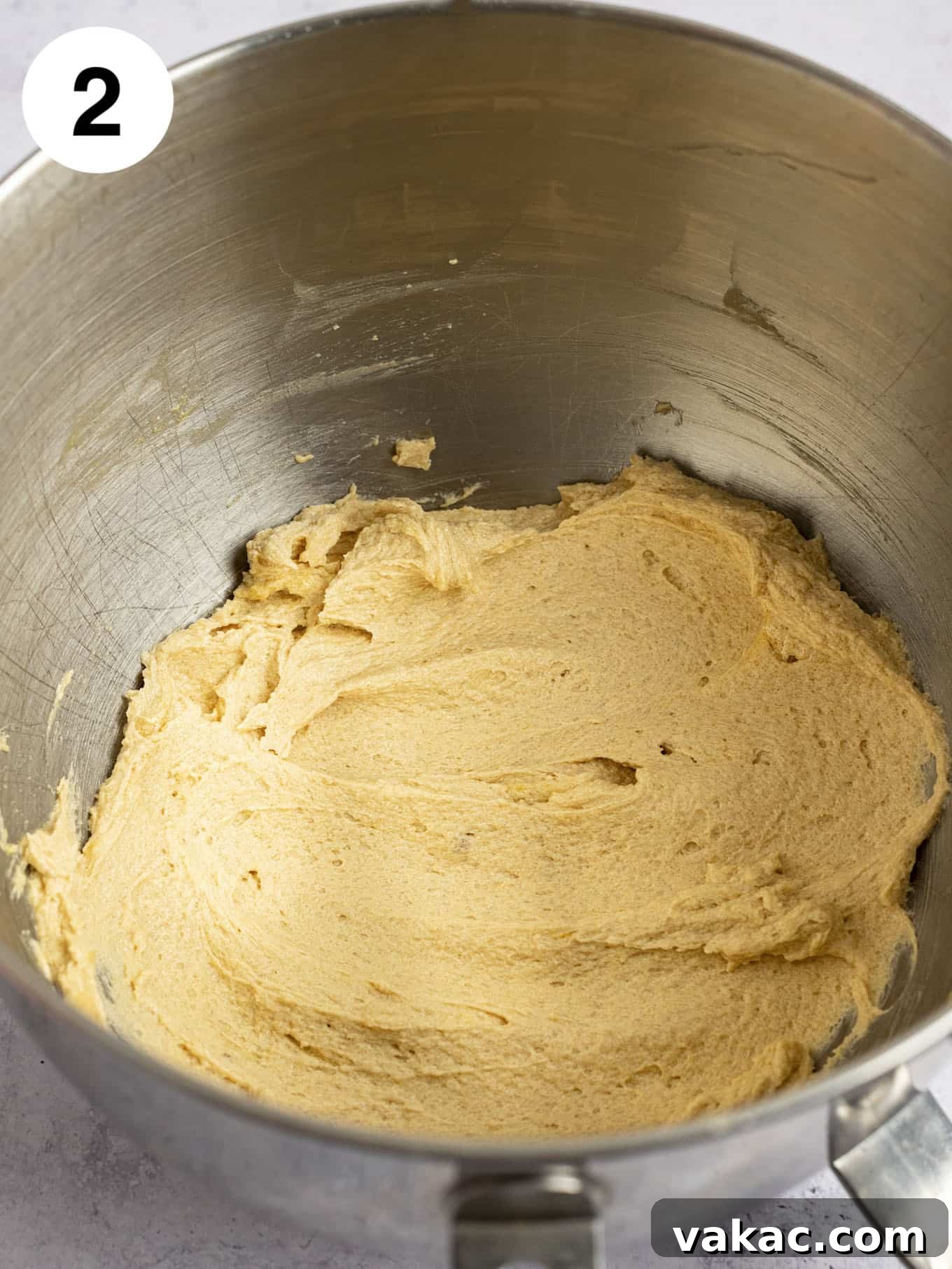 The wet ingredients, including butter, sugars, egg, egg yolk, and vanilla, expertly mixed in the bowl of a stand mixer.