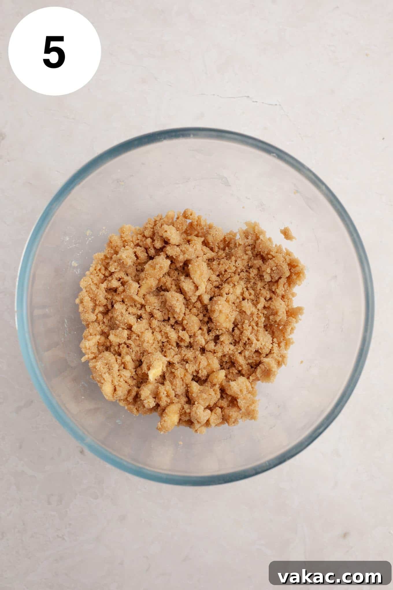 Berry Burst Bread 8 An overhead view of a small glass mixing bowl filled with cinnamon streusel topping, featuring a perfect crumbly mixture of butter, flour, and brown sugar, ready to top the blueberry bread.