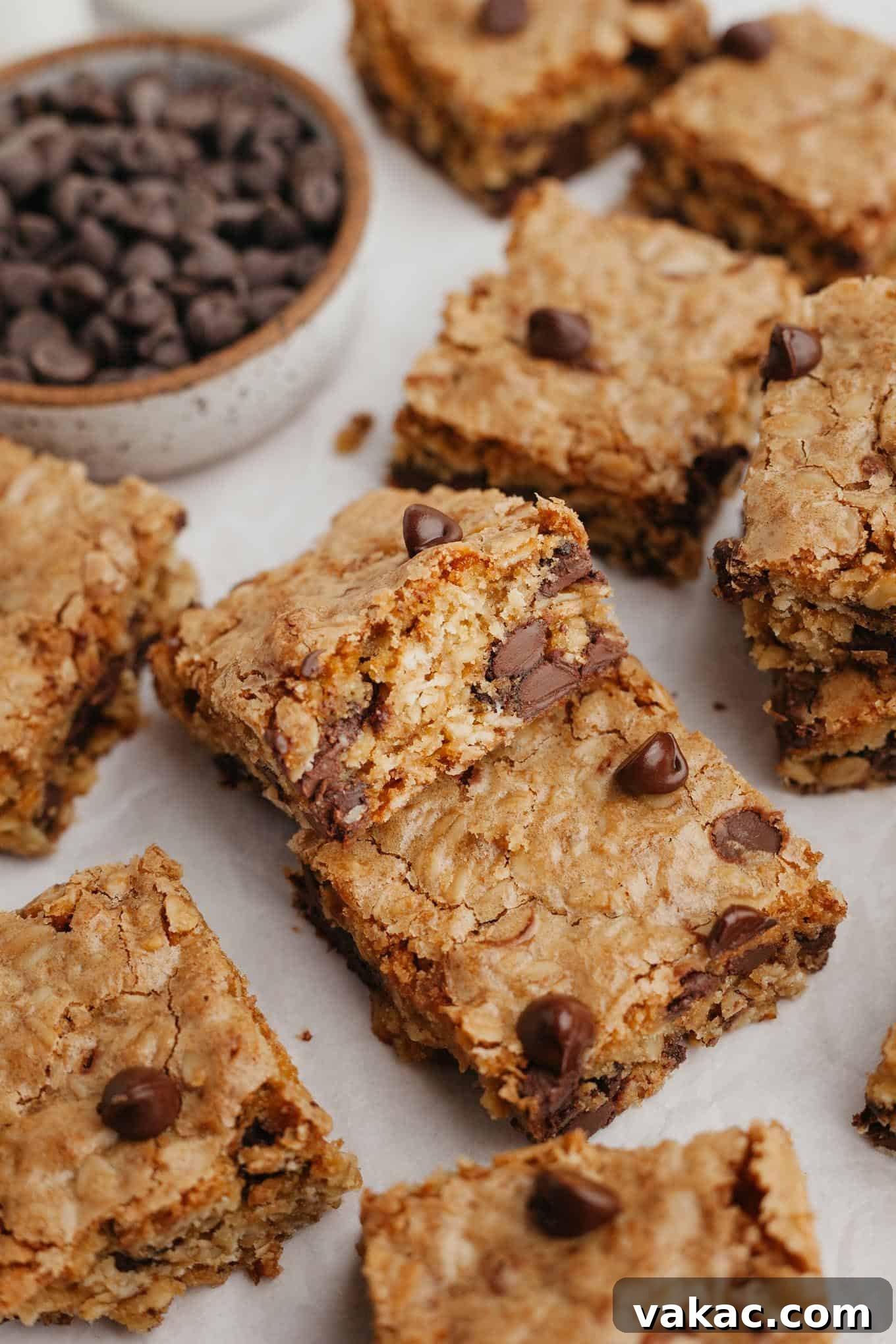 Golden Oatmeal Bars 9 A beautiful arrangement of oatmeal bar cookies scattered artfully on a pristine white surface, highlighting their homemade appeal.
