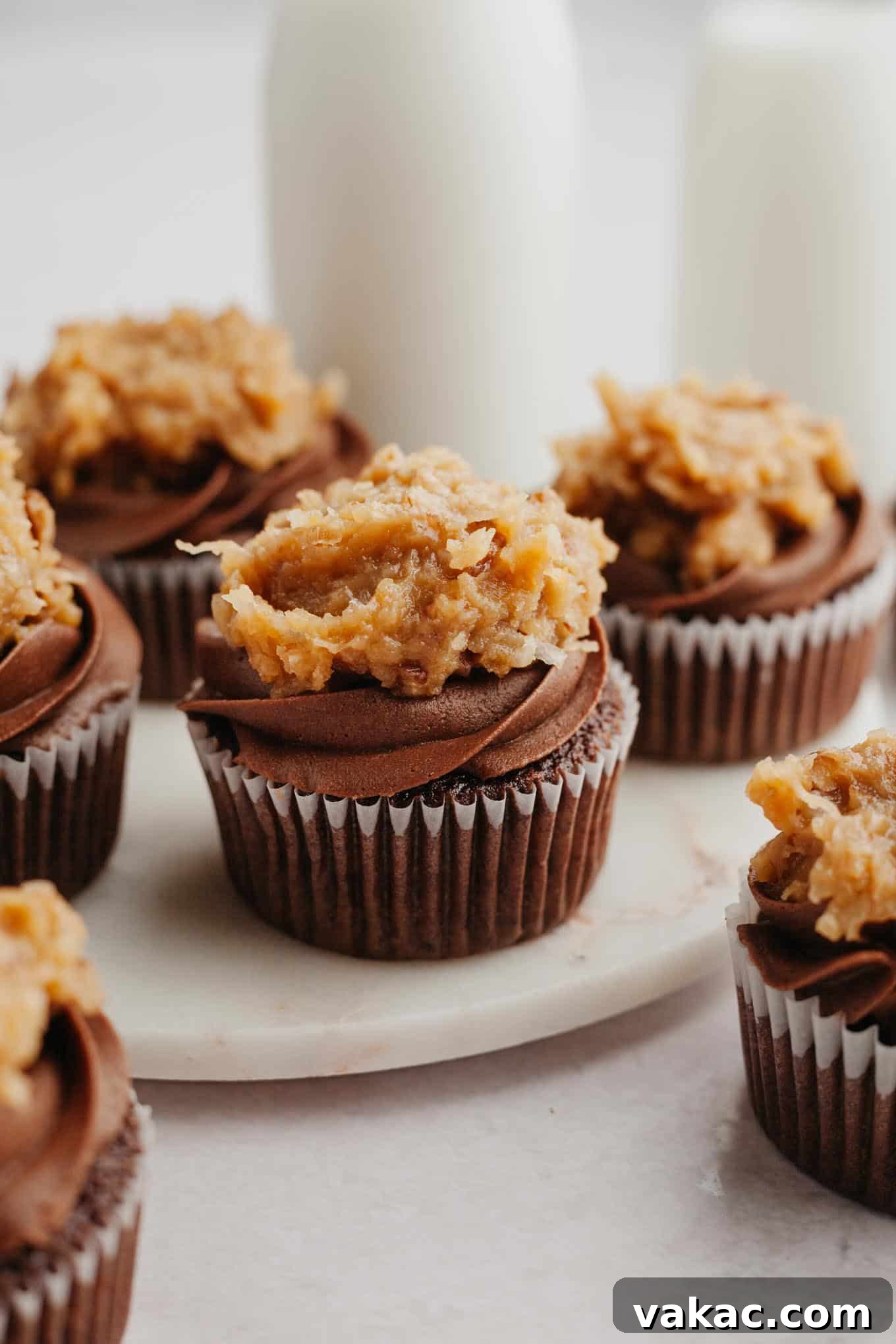Ultimate German Chocolate Cupcakes 2 Frosted German chocolate cupcakes on a marble serving platter.