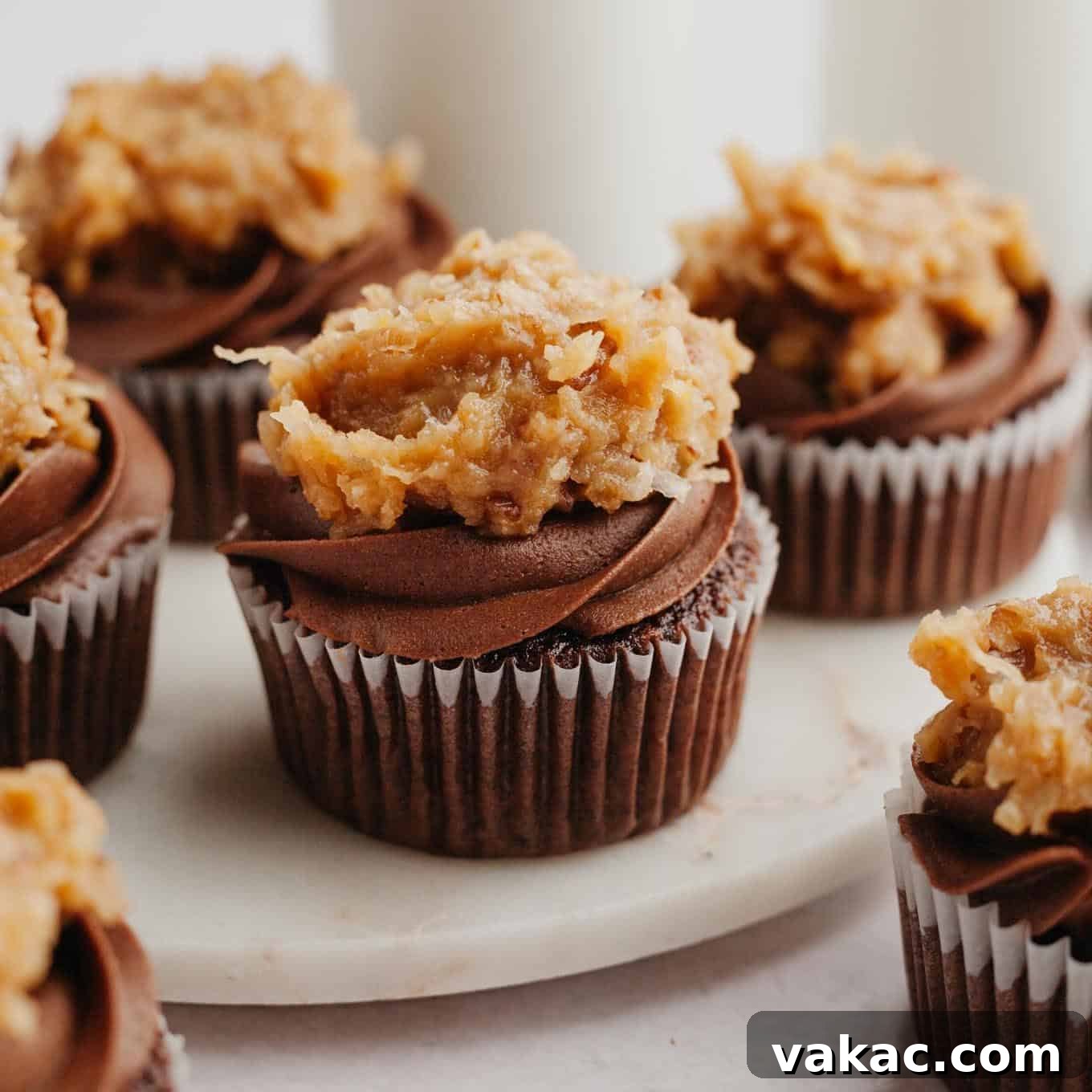 Ultimate German Chocolate Cupcakes 15 Several German Chocolate cupcakes on a marble serving plate.