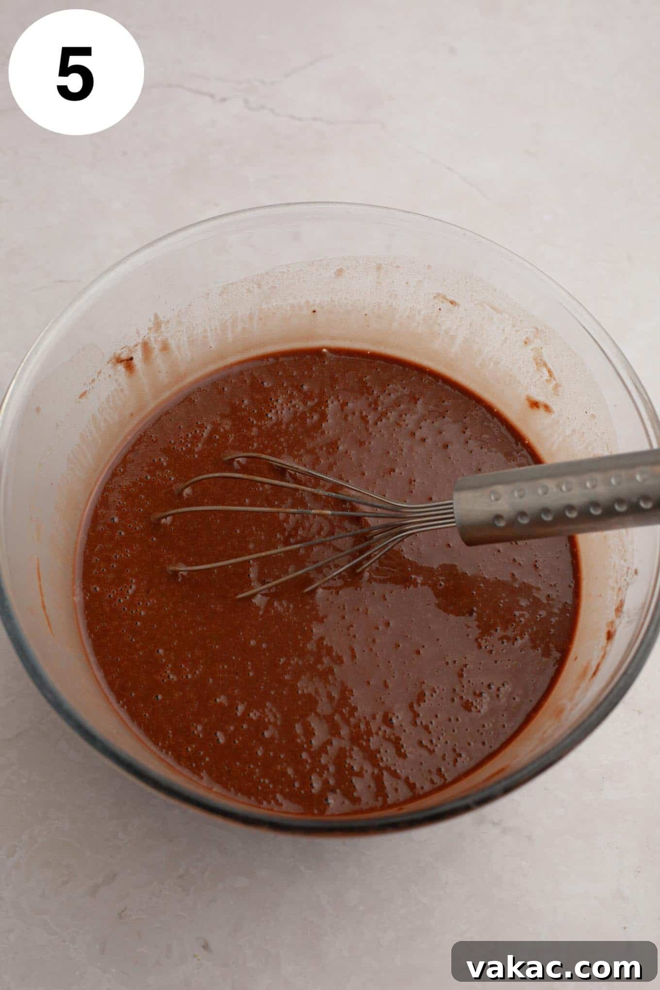 Ultimate German Chocolate Cupcakes 9 An overhead view of chocolate cupcake batter in a glass mixing bowl, with a whisk.