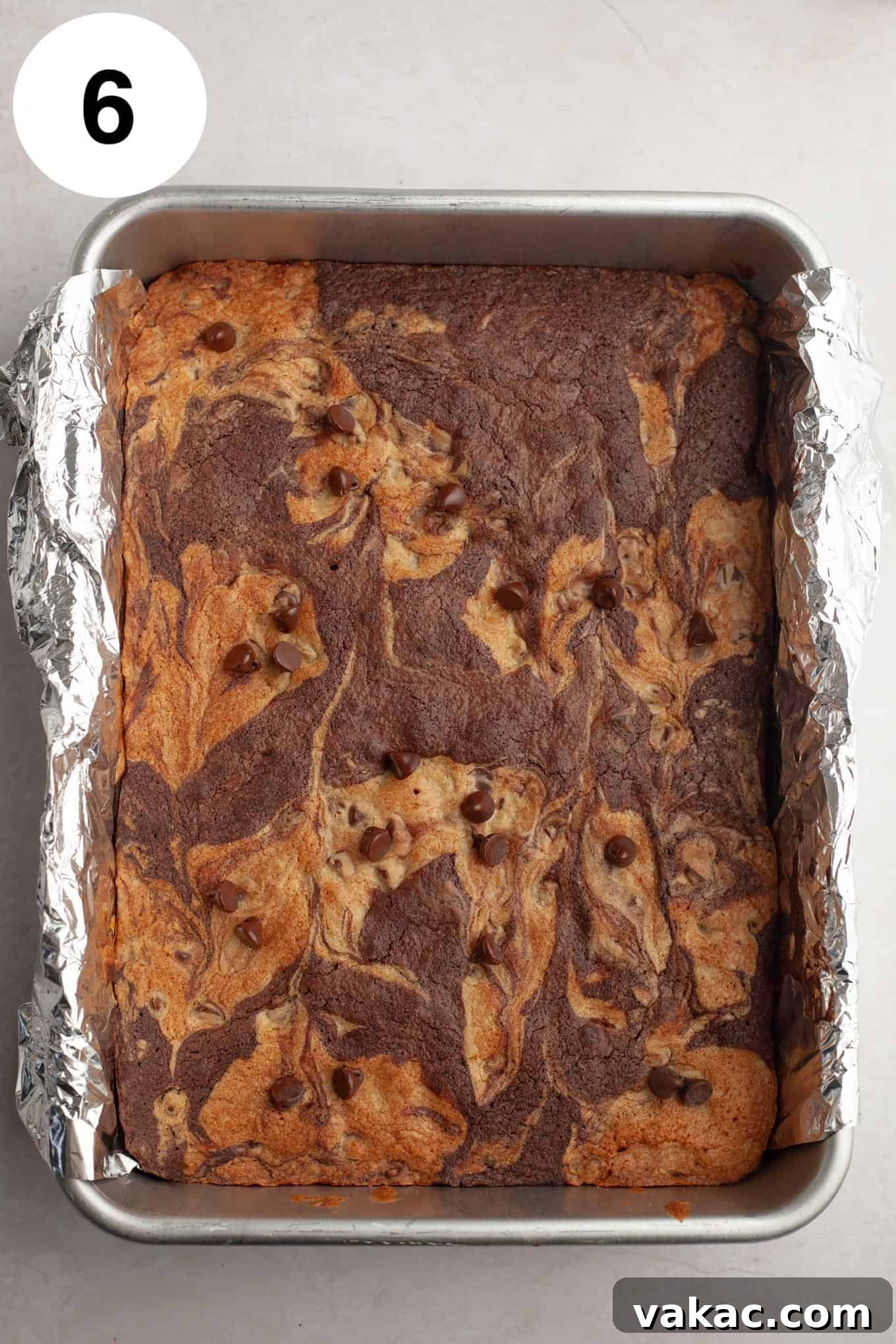 An overhead view of baked brookie bars in a foil-lined pan. 