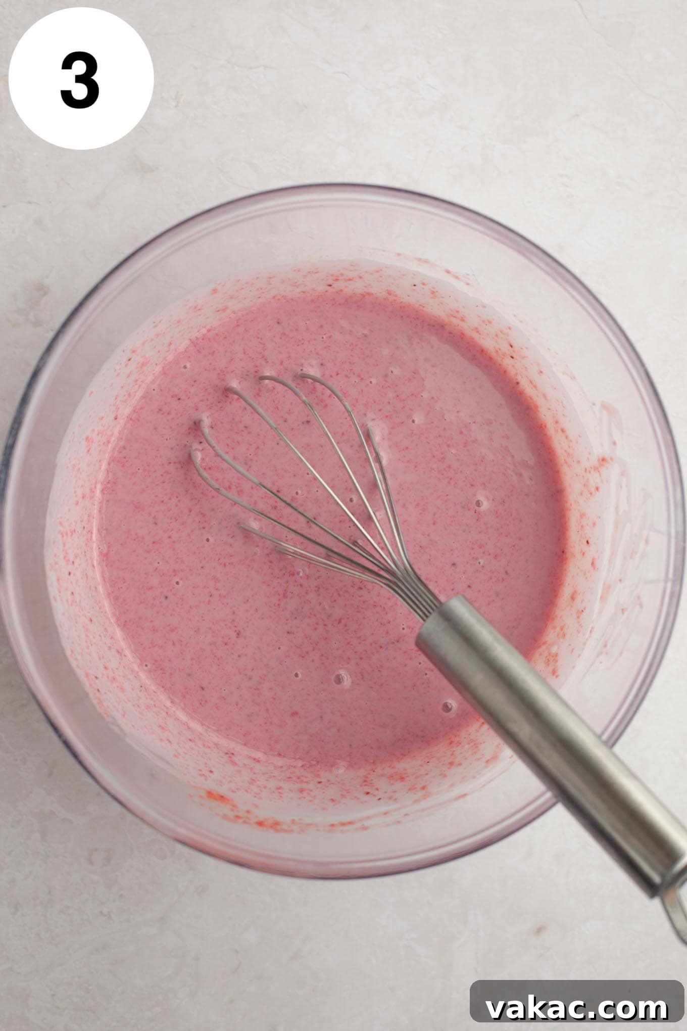 Strawberry Dream Cream 6 An overhead view of sweetened condensed milk combined with the cooled, reduced strawberry mixture in a clear glass mixing bowl, ready for whisking.