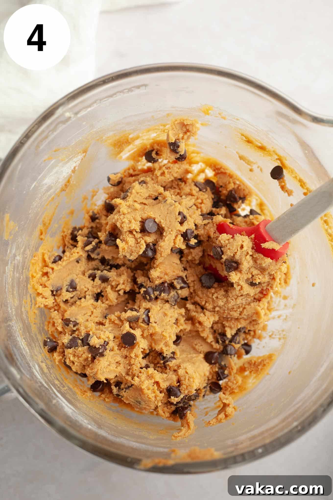 Peanut Butter Chocolate Bliss Bites 7 The finished peanut butter chocolate chip cookie dough in a glass mixing bowl, with melty chocolate chips beautifully folded in, ready for scooping and baking.