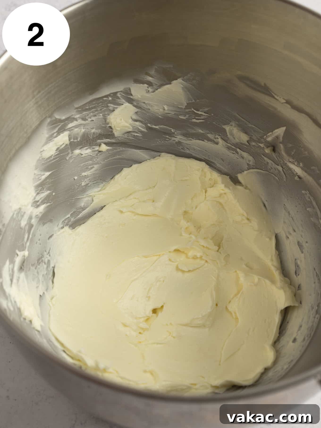 Java Dream Frost 5 Perfectly beaten softened unsalted butter in the shiny bowl of a stand mixer, showcasing its light, airy, and creamy consistency, indicating it's ready for the next stages of frosting preparation.
