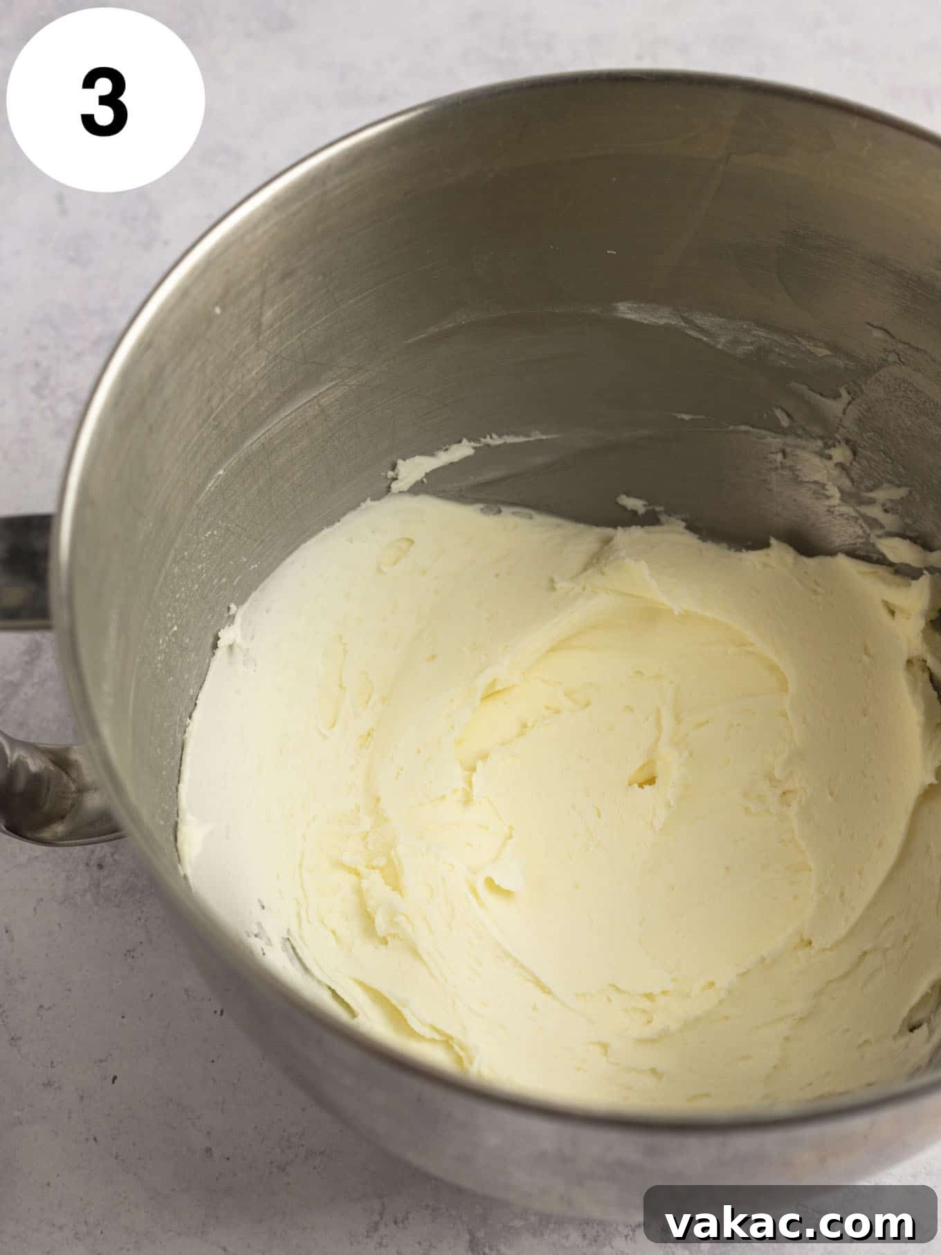 Java Dream Frost 6 Softened butter and powdered sugar being gradually beaten together in the bowl of a stand mixer, illustrating the careful process of incorporating sugar to prevent lumps.