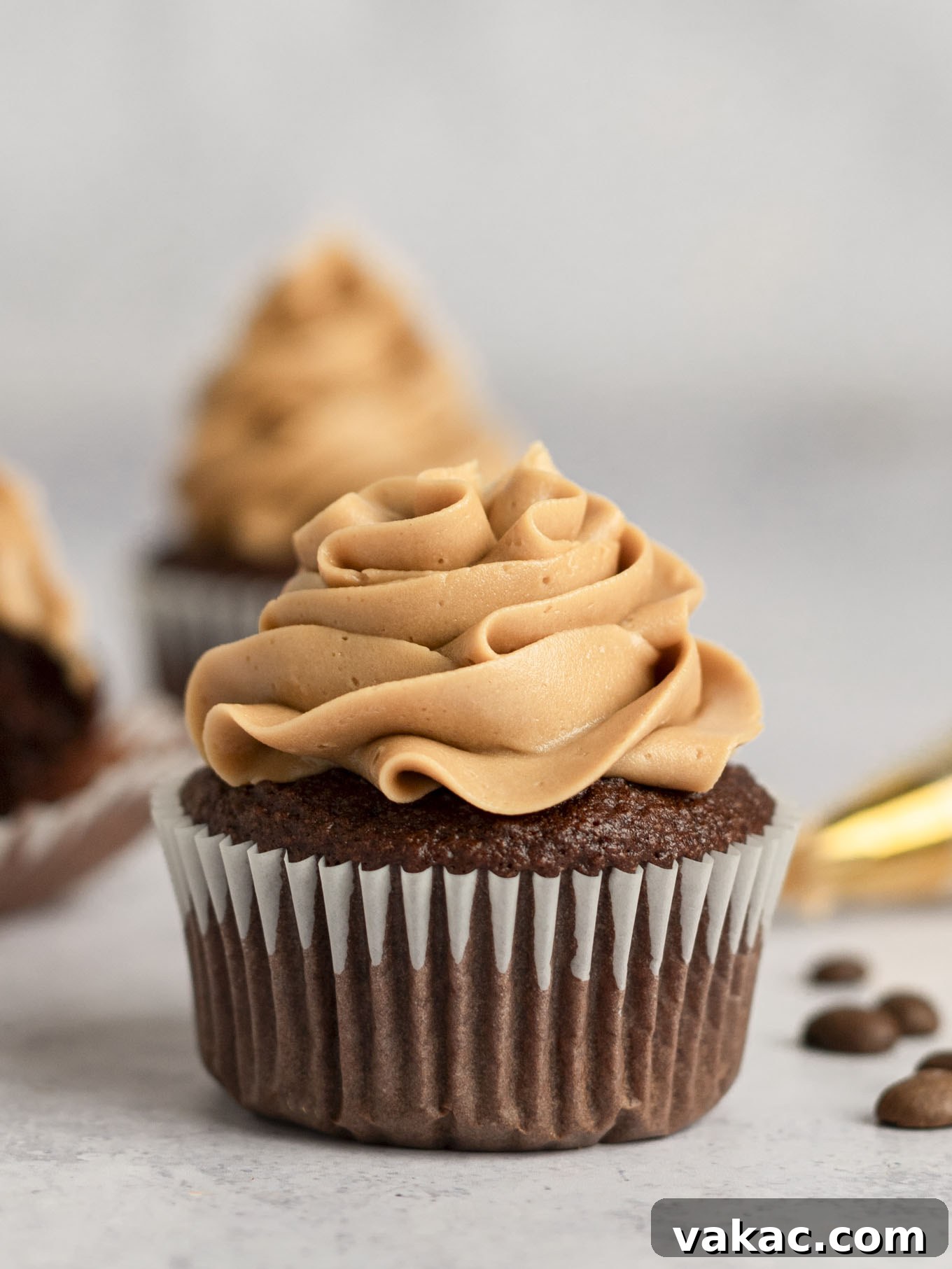 Java Dream Frost 8 A beautifully frosted chocolate cupcake generously topped with a perfect swirl of coffee frosting, presented on a small plate and ready to be savored.