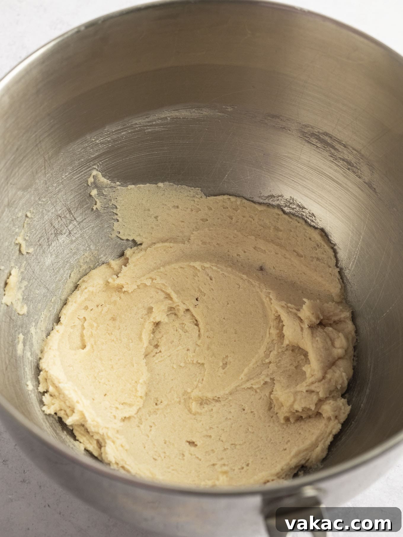 Irresistible White Chocolate Delights 4 Creamed unsalted butter and a mix of brown and granulated sugars in the stainless steel bowl of a stand mixer, demonstrating the proper light, fluffy, and well-combined texture after adequate mixing.