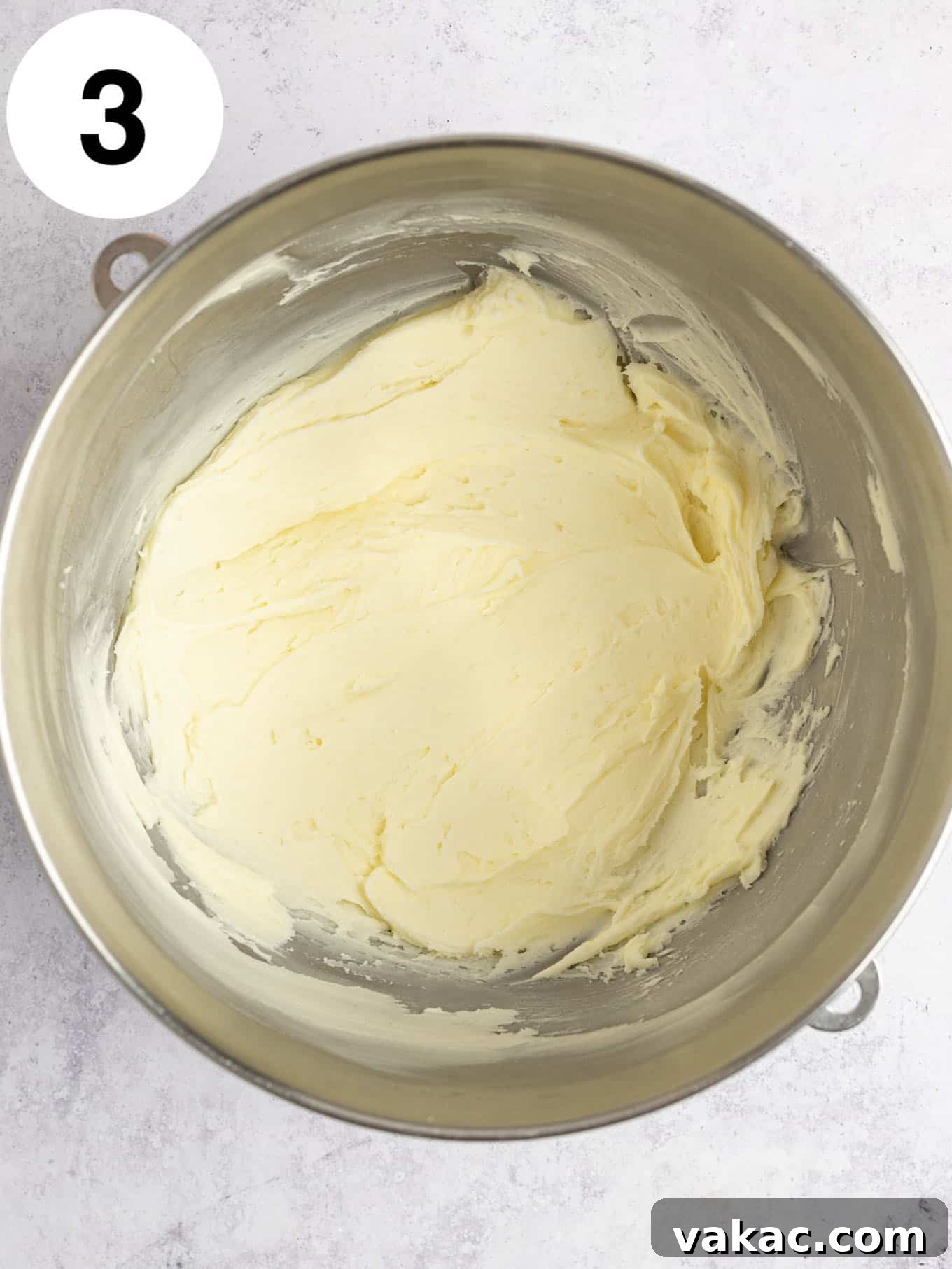 Velvet Raspberry Icing 6 An overhead shot of softened butter and powdered sugar being beaten together in a large mixing bowl, creating a creamy base for the frosting.