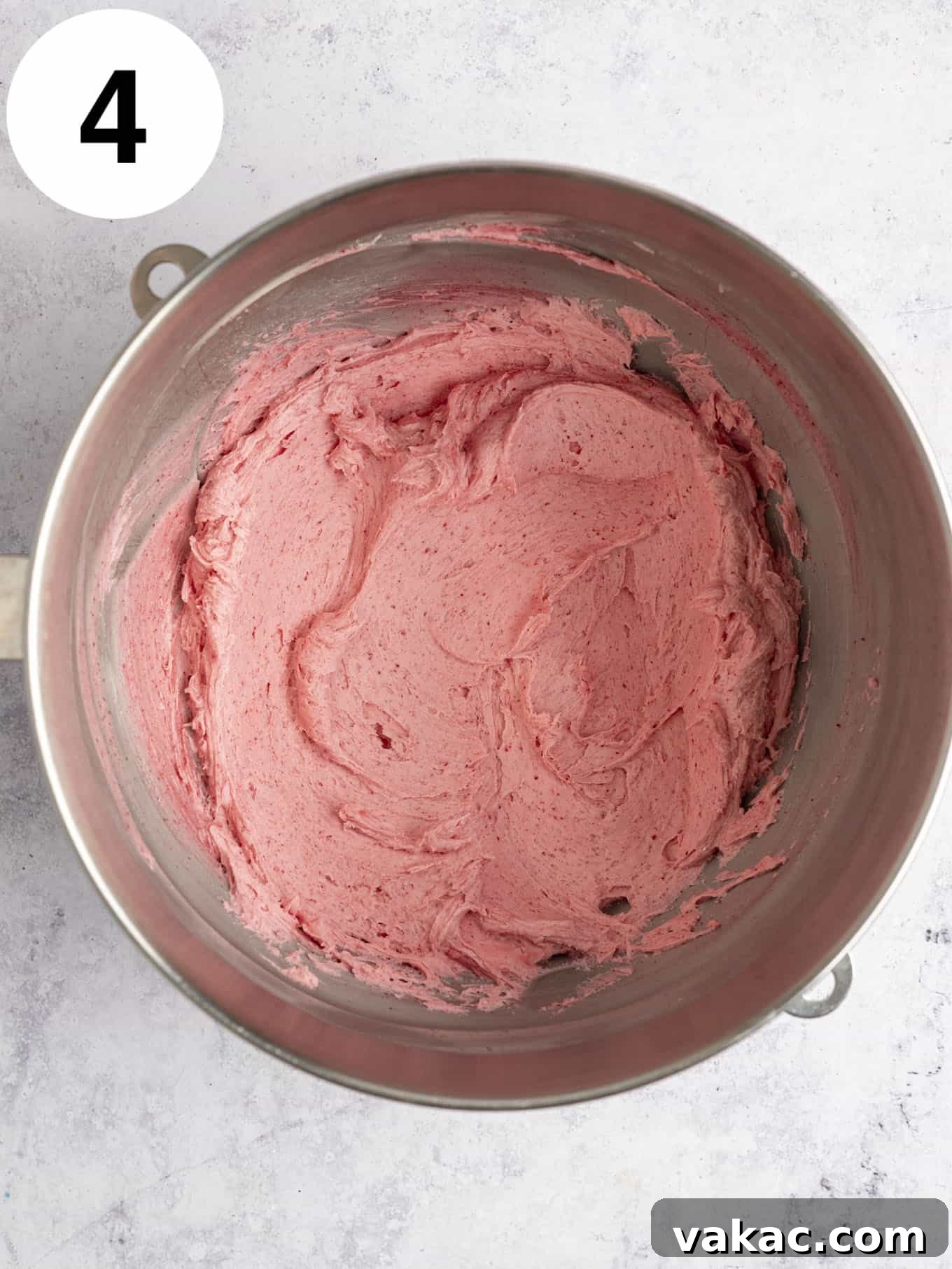 Velvet Raspberry Icing 7 An overhead view of the completed vibrant pink raspberry frosting in a mixing bowl, showcasing its smooth and fluffy texture.