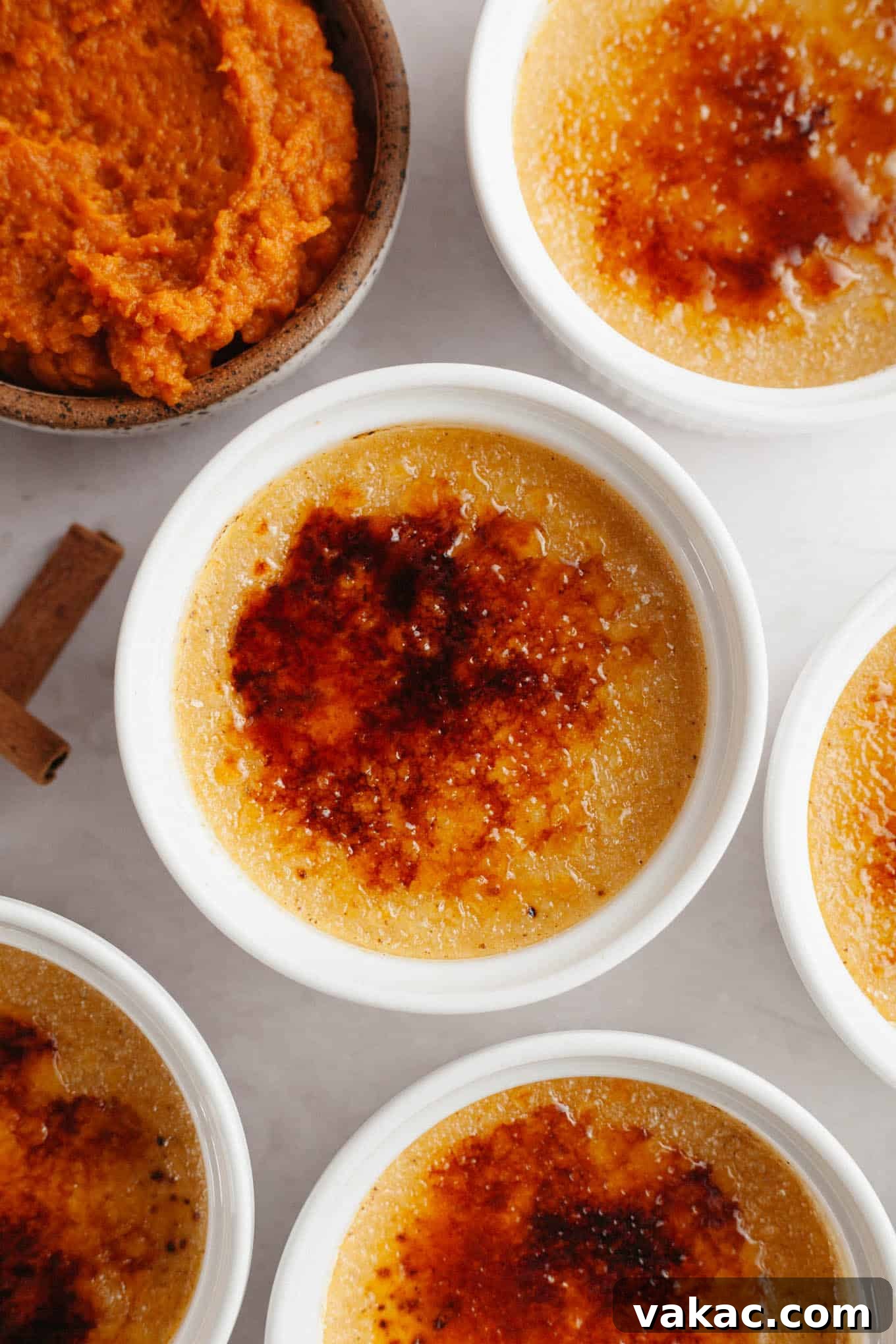 Spiced Pumpkin Creme Brulee 2 An overhead view of pumpkin crème brûlée in individual ramekins, ready to be served, showcasing its vibrant fall color.