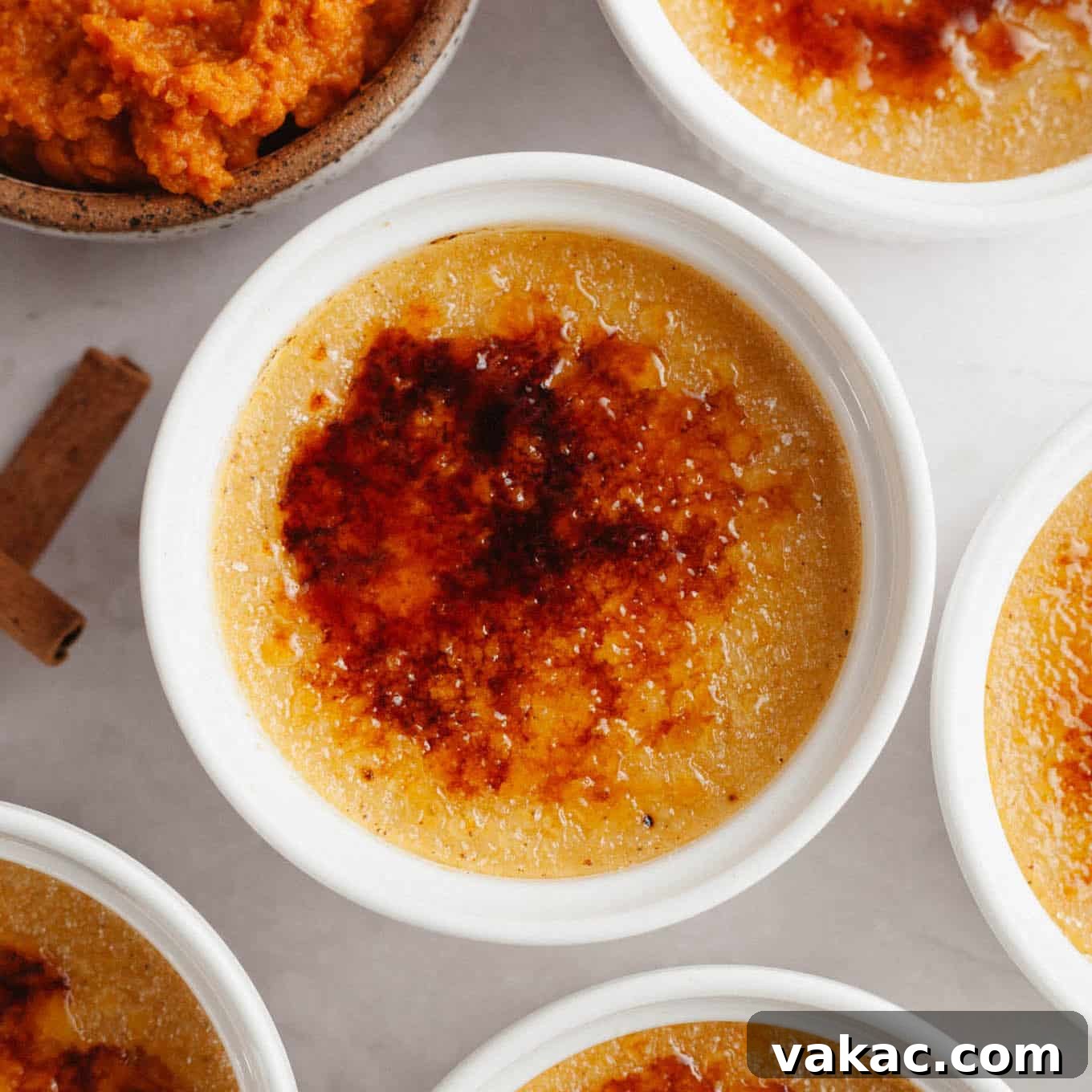 An overhead view of pumpkin creme brûlée in individual serving dishes, showcasing the perfect caramelized topping.
