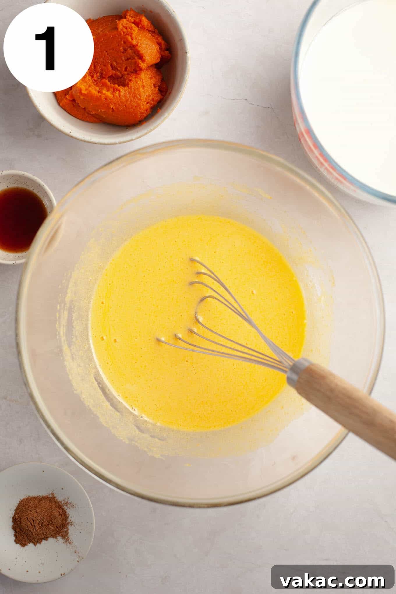 Spiced Pumpkin Creme Brulee 4 An overhead view of a bowl containing perfectly whisked egg yolks and granulated sugar, forming a light, creamy mixture.
