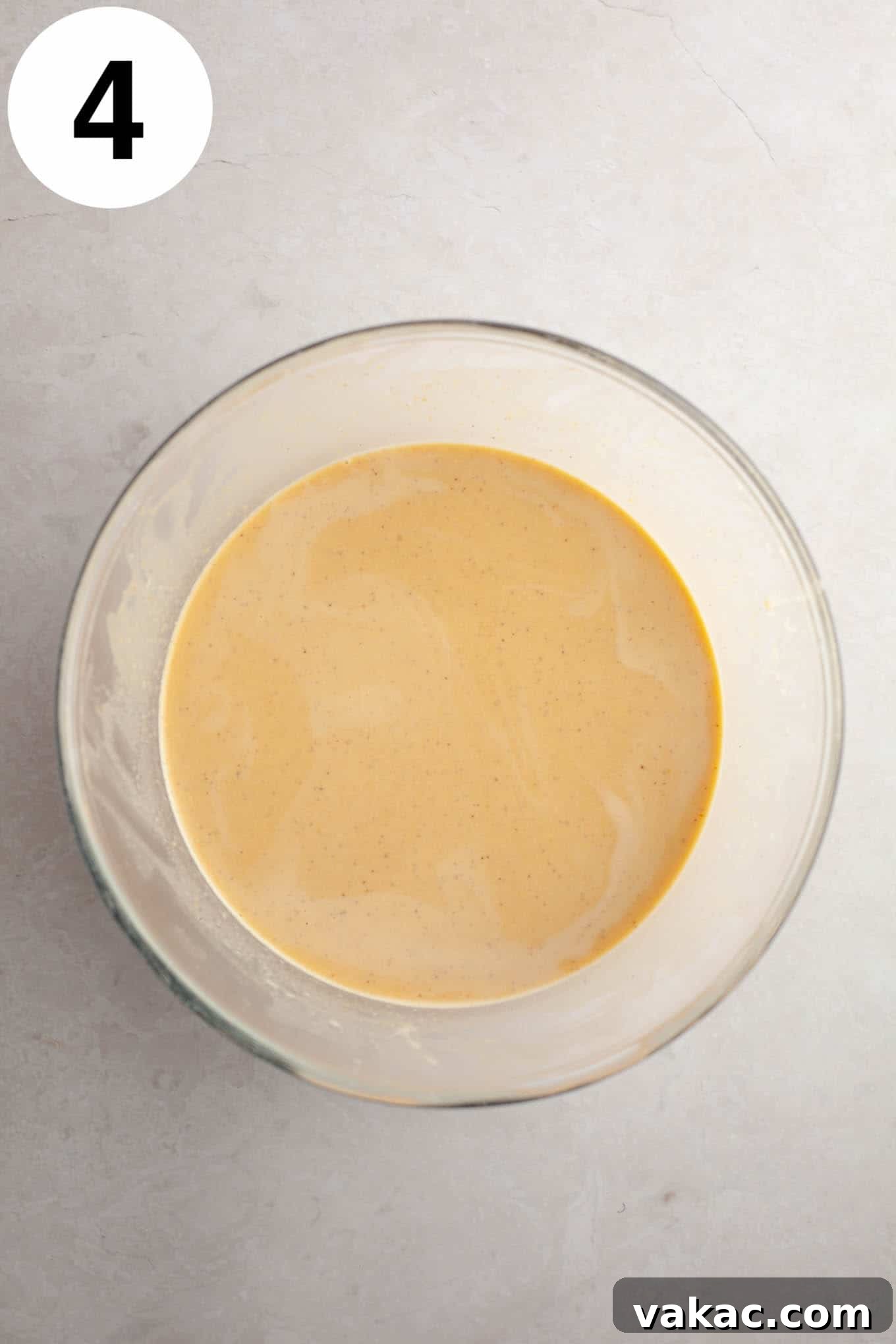 Spiced Pumpkin Creme Brulee 7 An overhead view of the raw pumpkin crème brûlée filling in a clear glass mixing bowl, looking smooth and ready for the ramekins.