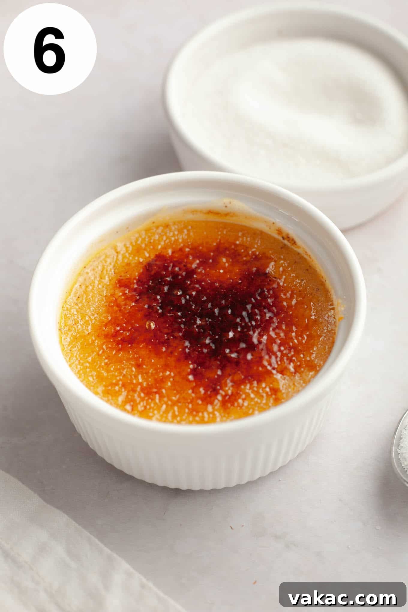 Spiced Pumpkin Creme Brulee 9 A single ramekin of perfectly baked and chilled pumpkin spice crème brûlée, with a small dish of granulated sugar next to it, awaiting the caramelization step.