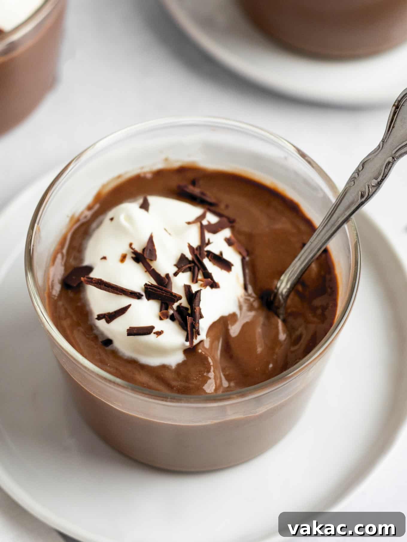 Silky Chocolate Indulgence 2 Homemade chocolate pudding garnished with whipped cream and chocolate shavings in a glass serving dish.