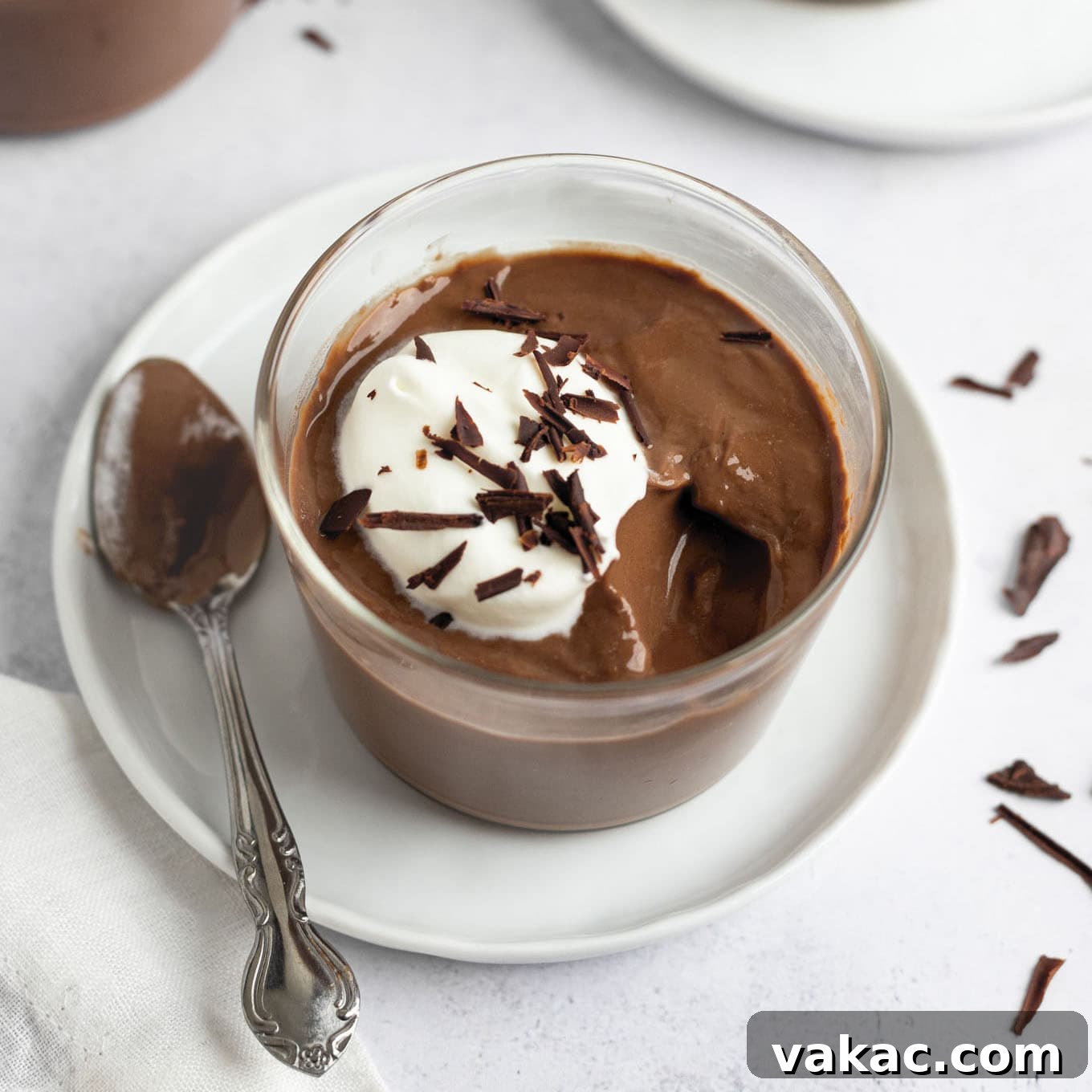 A glass filled with chocolate pudding.