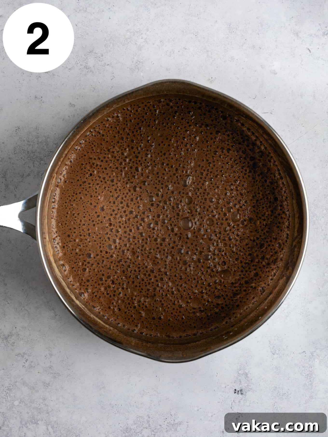 Silky Chocolate Indulgence 5 An overhead view of a milk and cocoa powder mixture in a metal saucepan.