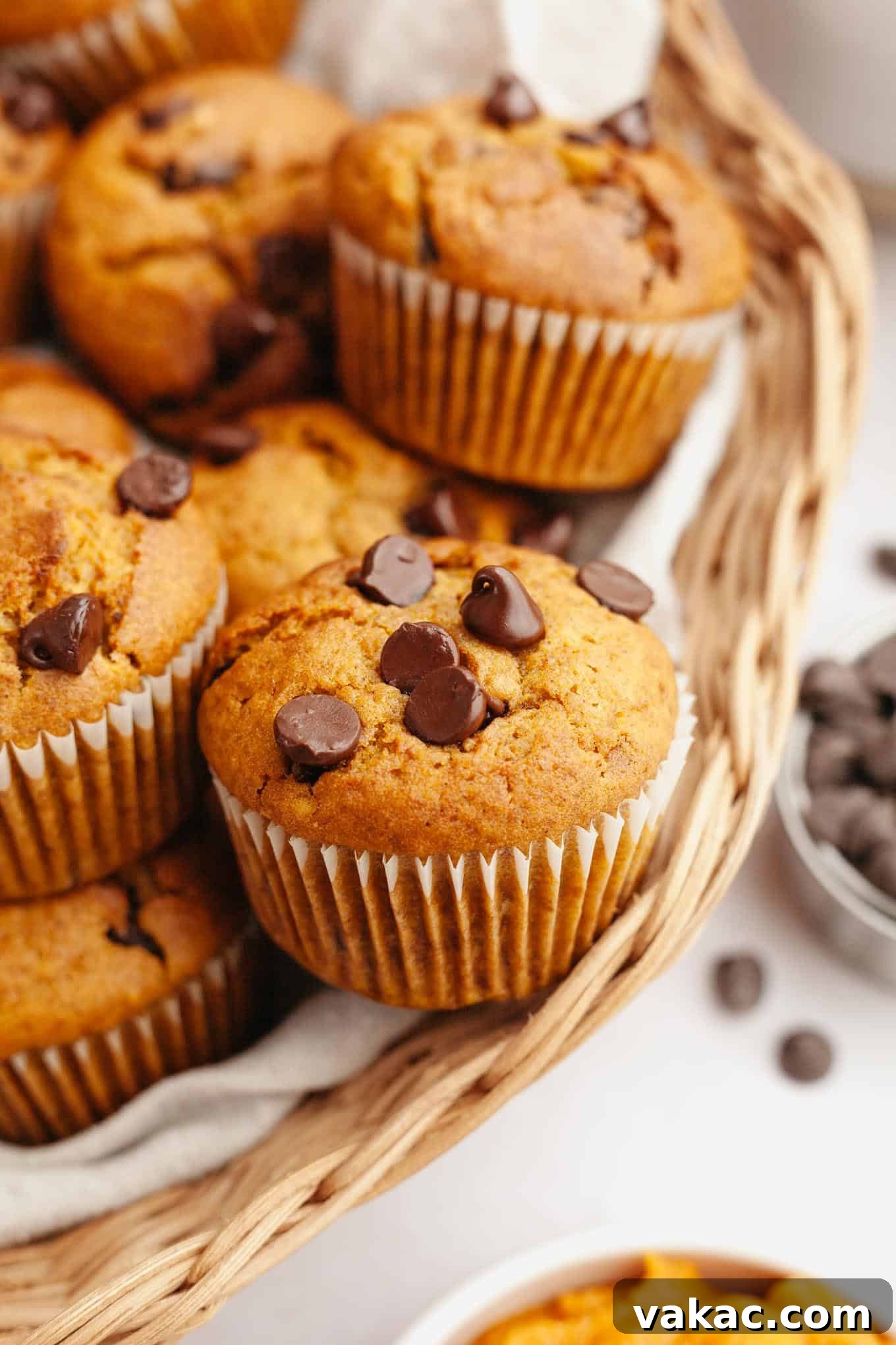 Harvest Pumpkin Chocolate Chip Muffins 2 Chocolate chip and pumpkin muffins piled into a wicker serving basket.