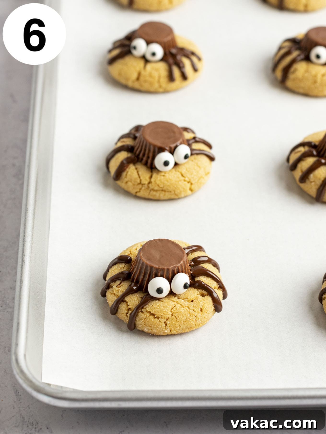 A process shot showing spider cookies after the candy eyes have been added.