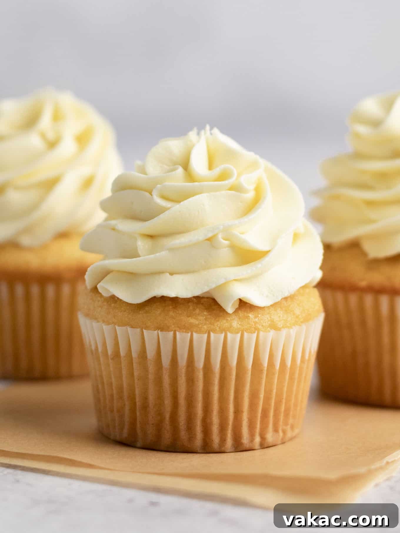 Velvet White Chocolate Frosting 2 A vanilla cupcake topped with luxurious white chocolate frosting, ready to be enjoyed.
