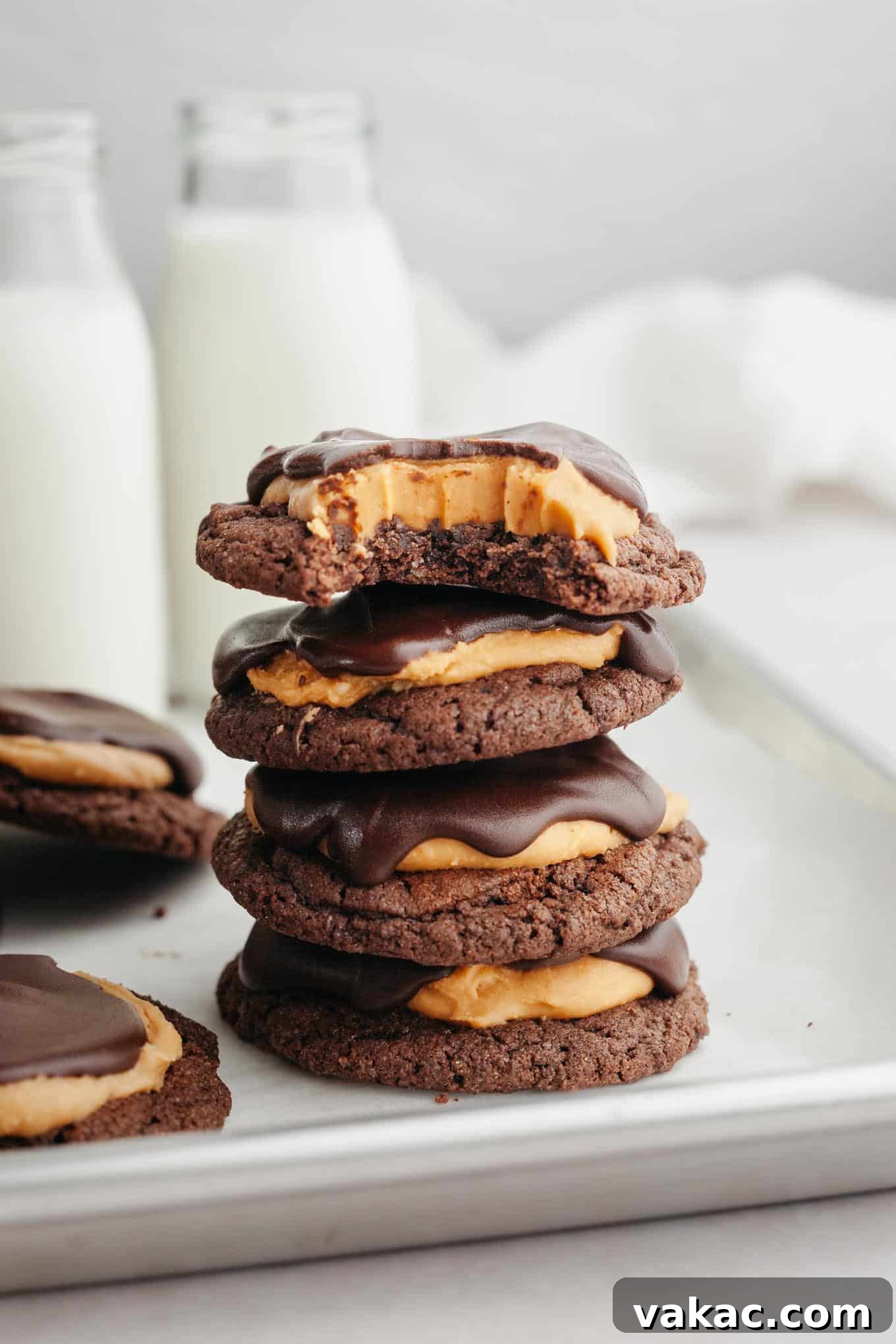 A stack of four Buckeye cookies; the top cookie is missing a bite.