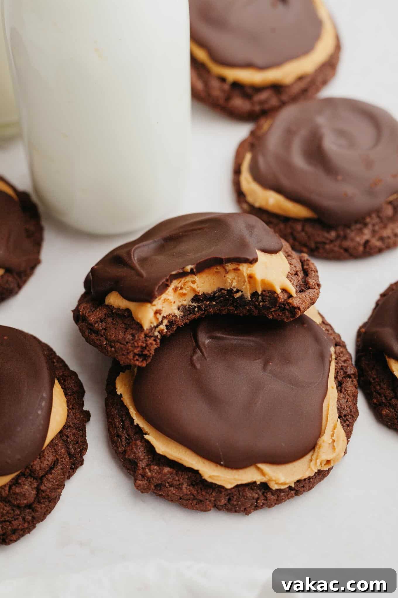 A close-up view of two Buckeye cookies; the top cookie has a bite missing.