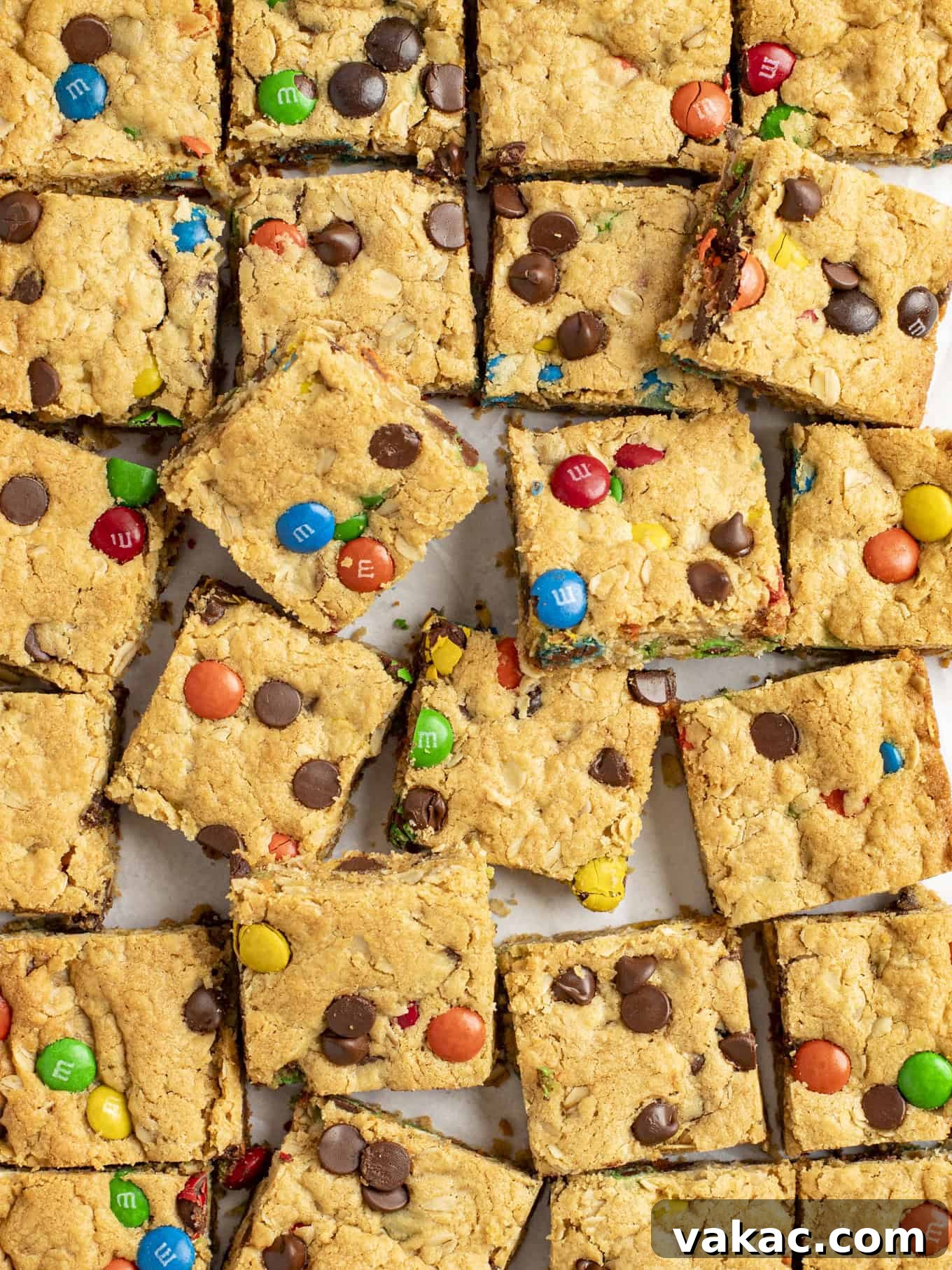 Ultimate Everything Cookie Bars 10 An overhead shot of perfectly sliced monster cookie bars arranged neatly on parchment paper, showcasing their chewy texture and colorful mix-ins.