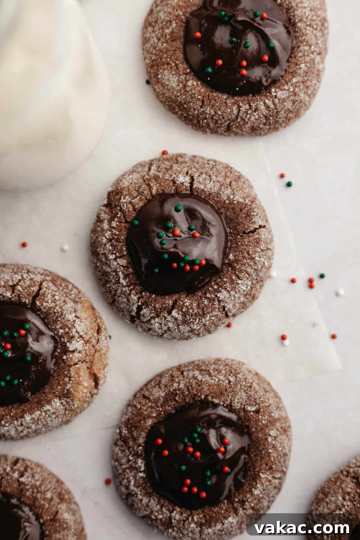 Decadent Chocolate Thumbprint Delights 11 An overhead view of festive chocolate thumbprint cookies topped with red and green nonpareils, perfect for the holidays.