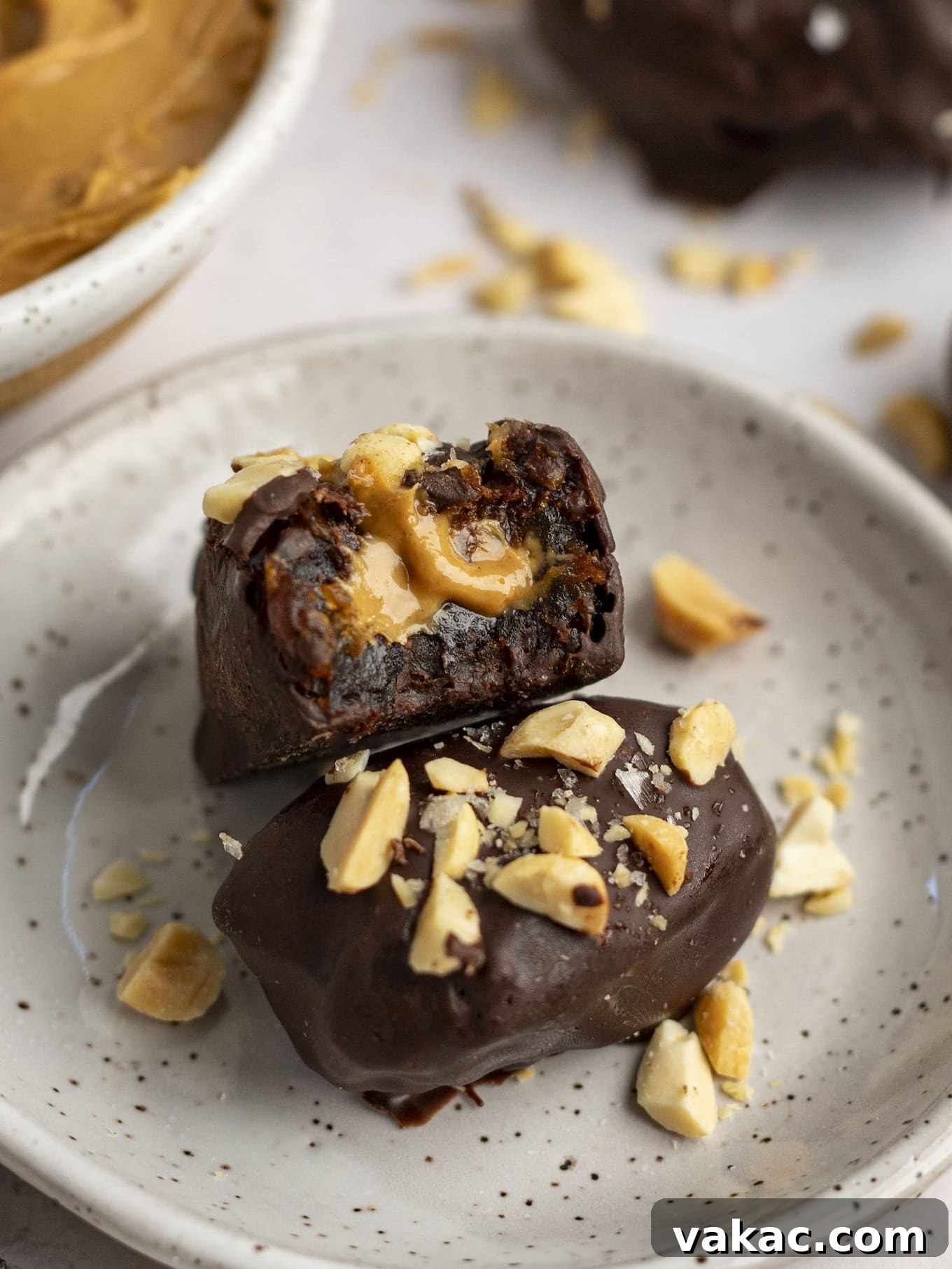Date Peanut Chocolate Bites 11 A peanut butter stuffed date with a bite missing, resting on another date.
