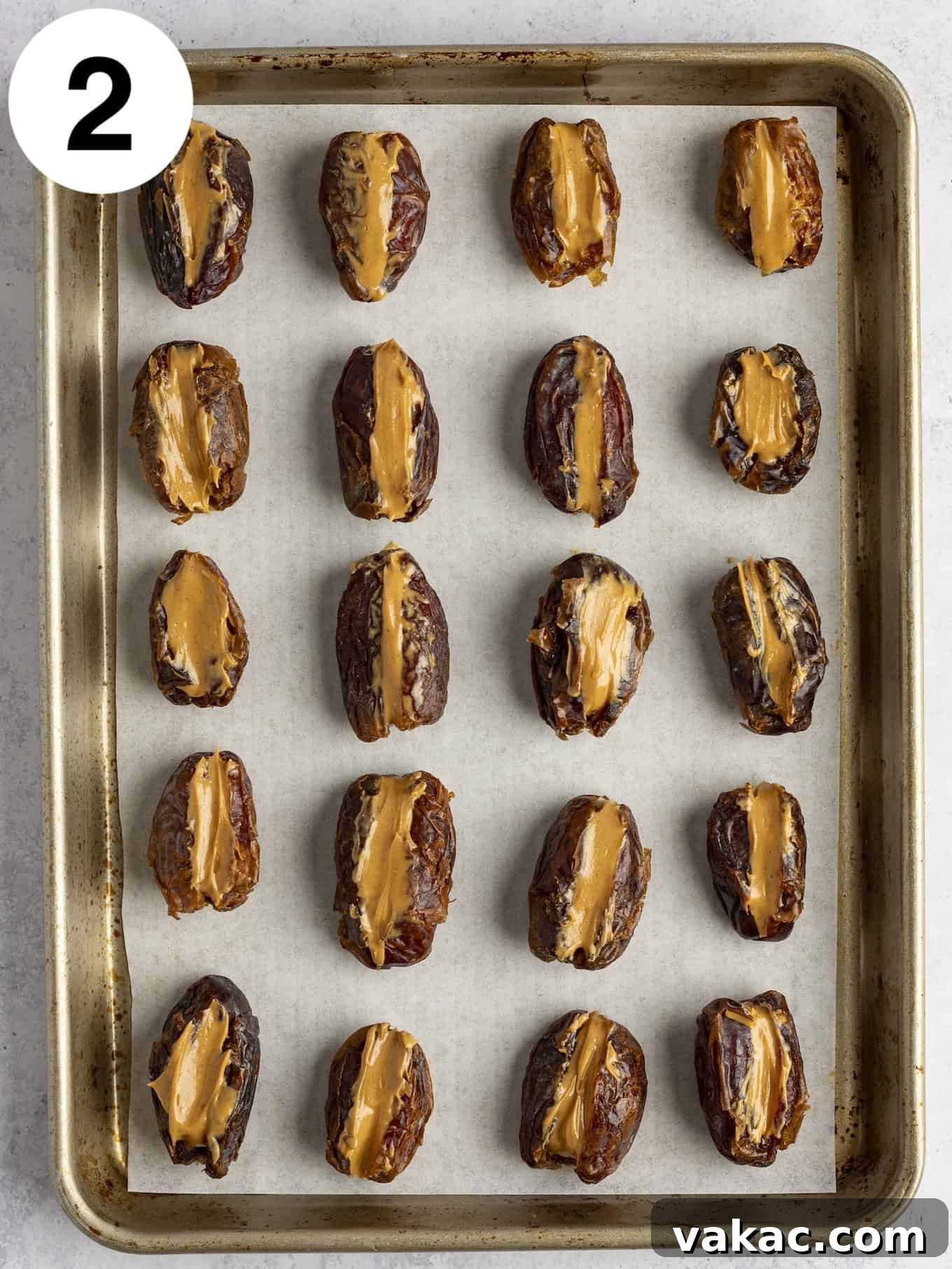 Date Peanut Chocolate Bites 5 An overhead view of peanut butter stuffed dates lined up on a baking sheet.