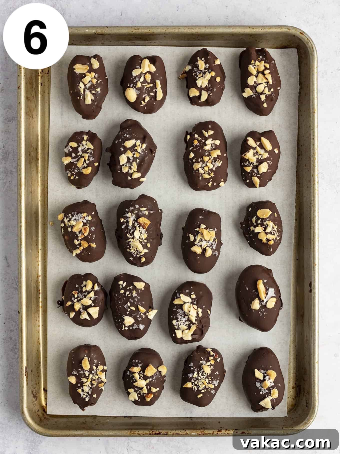 Date Peanut Chocolate Bites 9 An overhead view of chocolate covered dates lined up on a baking sheet.