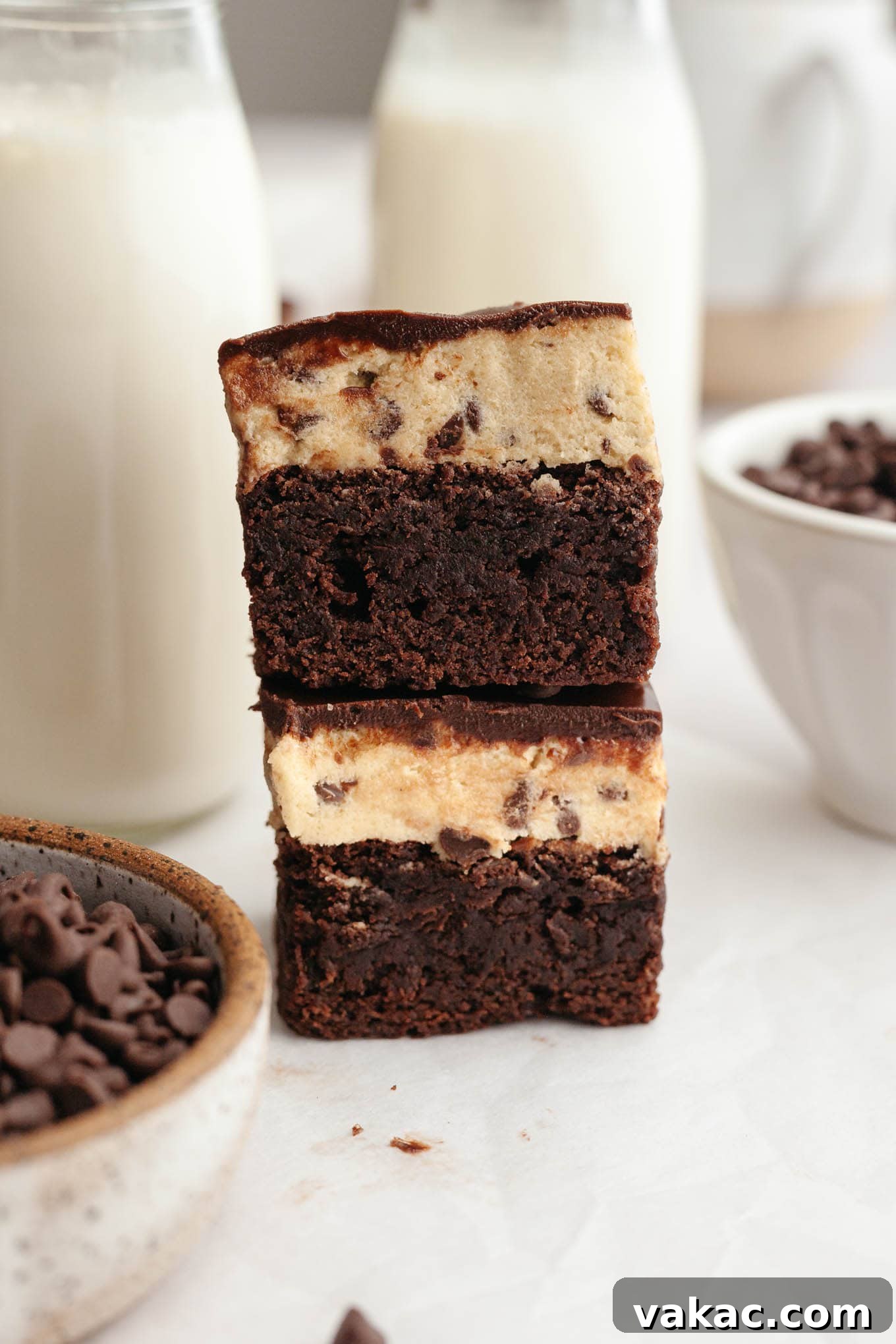 Brownie Cookie Dough Perfection 10 Two perfectly layered cookie dough brownies, stacked one on top of the other, revealing their distinct brownie, cookie dough, and chocolate layers.