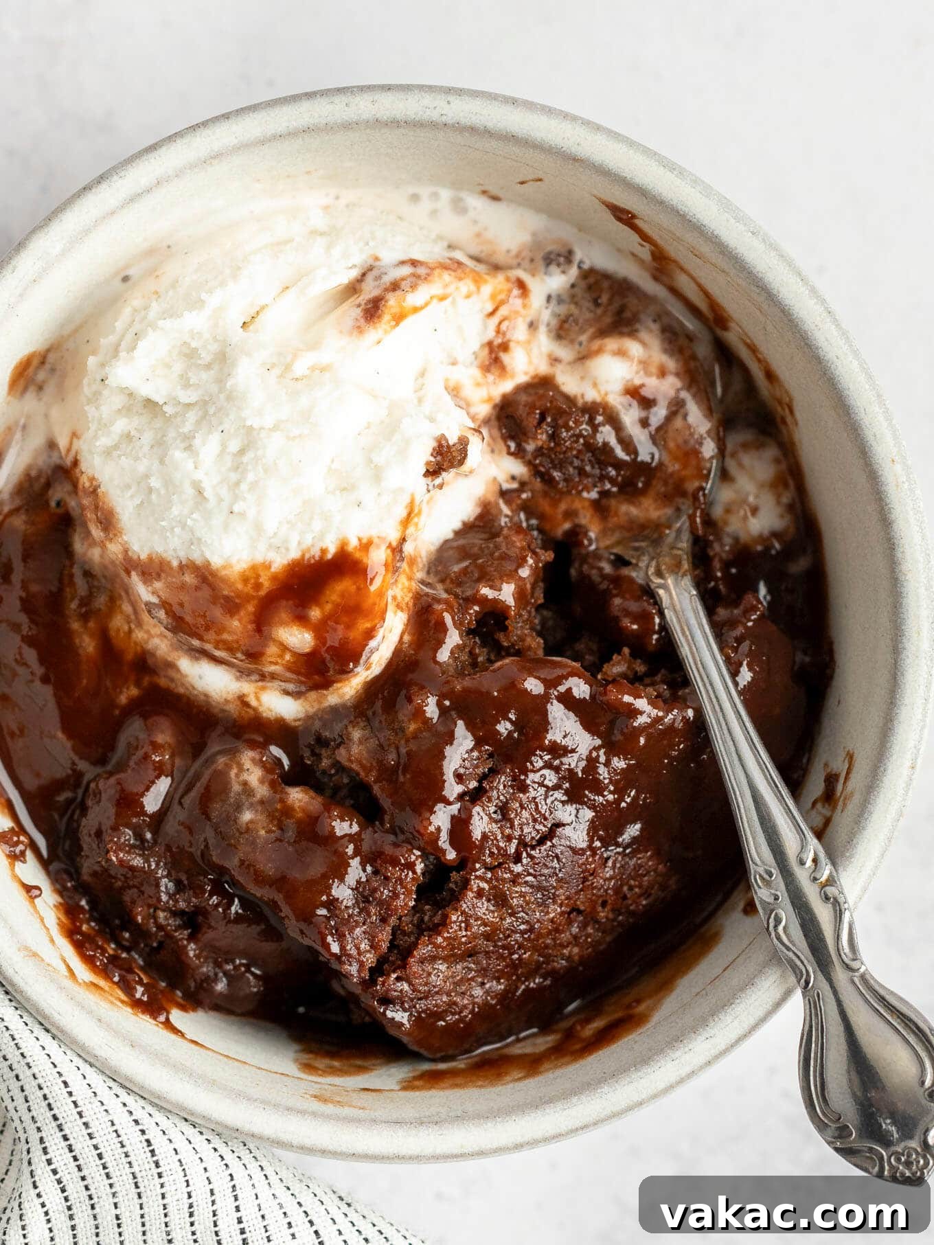 Velvet Chocolate Indulgence 11 An overhead view of chocolate pudding cake in a bowl, topped with vanilla ice cream.