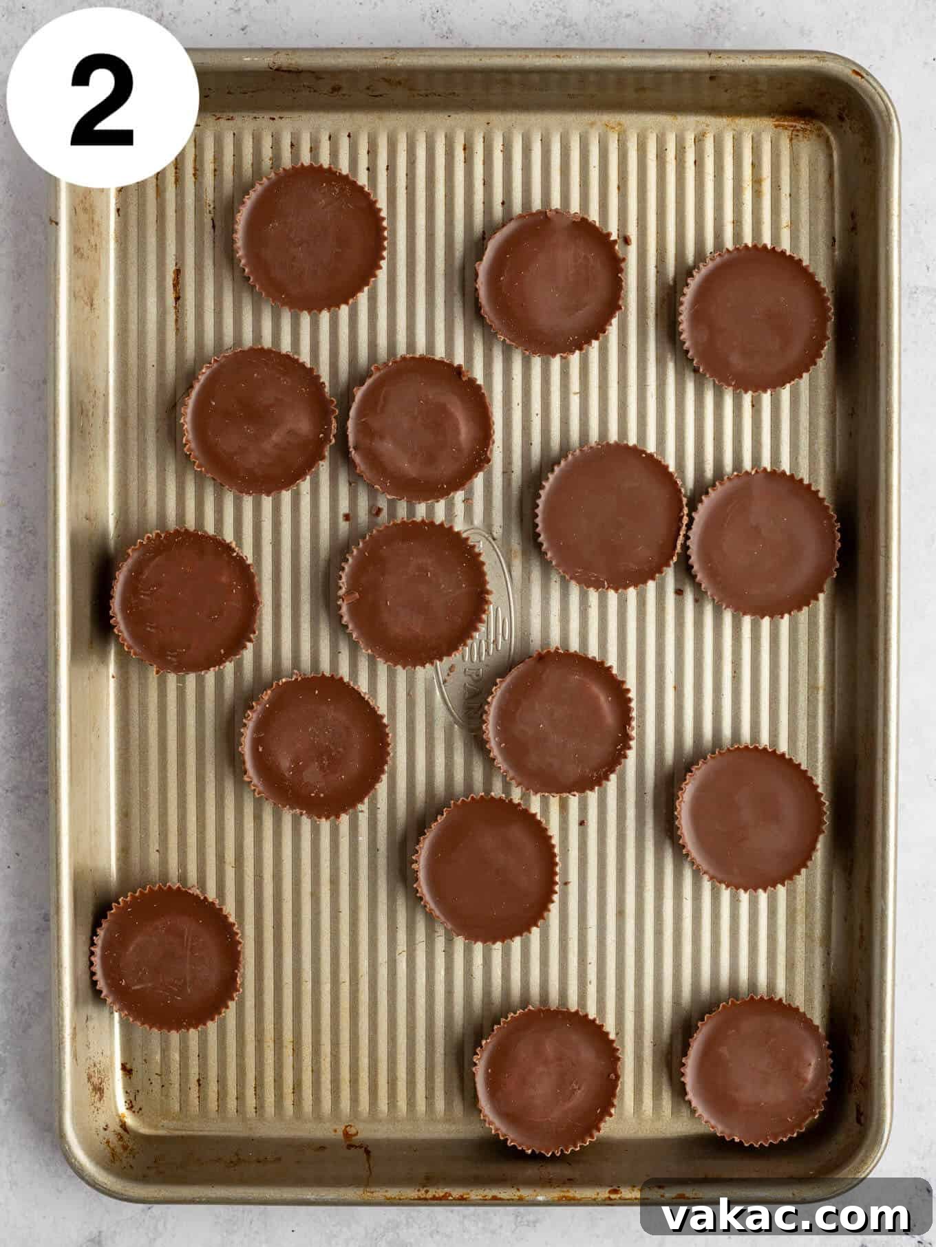 Reese's Peanut Butter Cup Overload Cookies 5 An overhead view of unwrapped Reese's peanut butter cups neatly arranged on a baking sheet, ready for freezing.