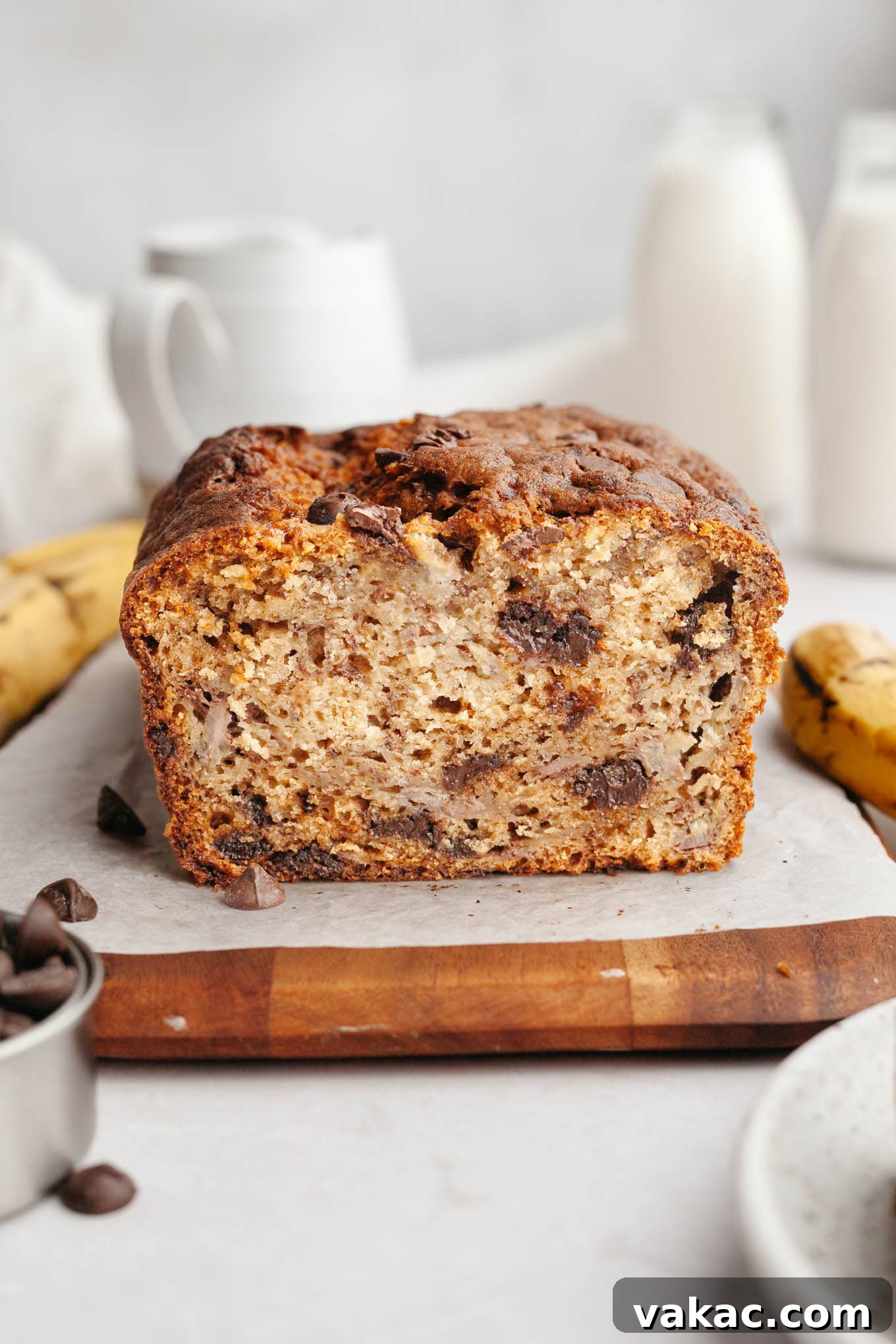 Decadent Chocolate Chip Banana Loaf 7 A beautiful loaf of sliced chocolate chip banana bread resting on a rustic wooden serving board, ready to be enjoyed.