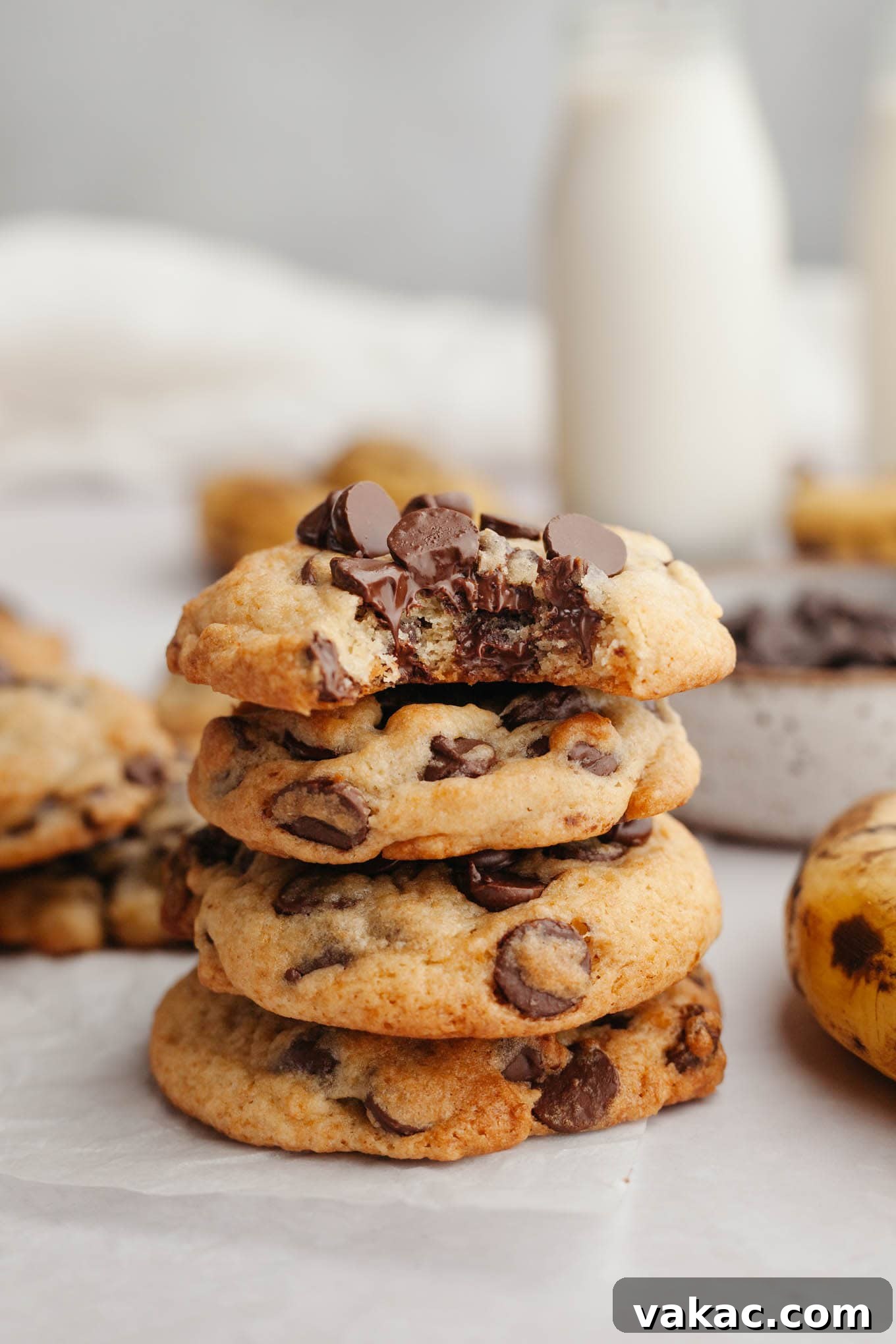 Banana Bliss Chocolate Chip Cookies 2 A stack of four banana chocolate chip cookies, with the top cookie missing a bite. Showing their soft, gooey centers and golden-brown edges.