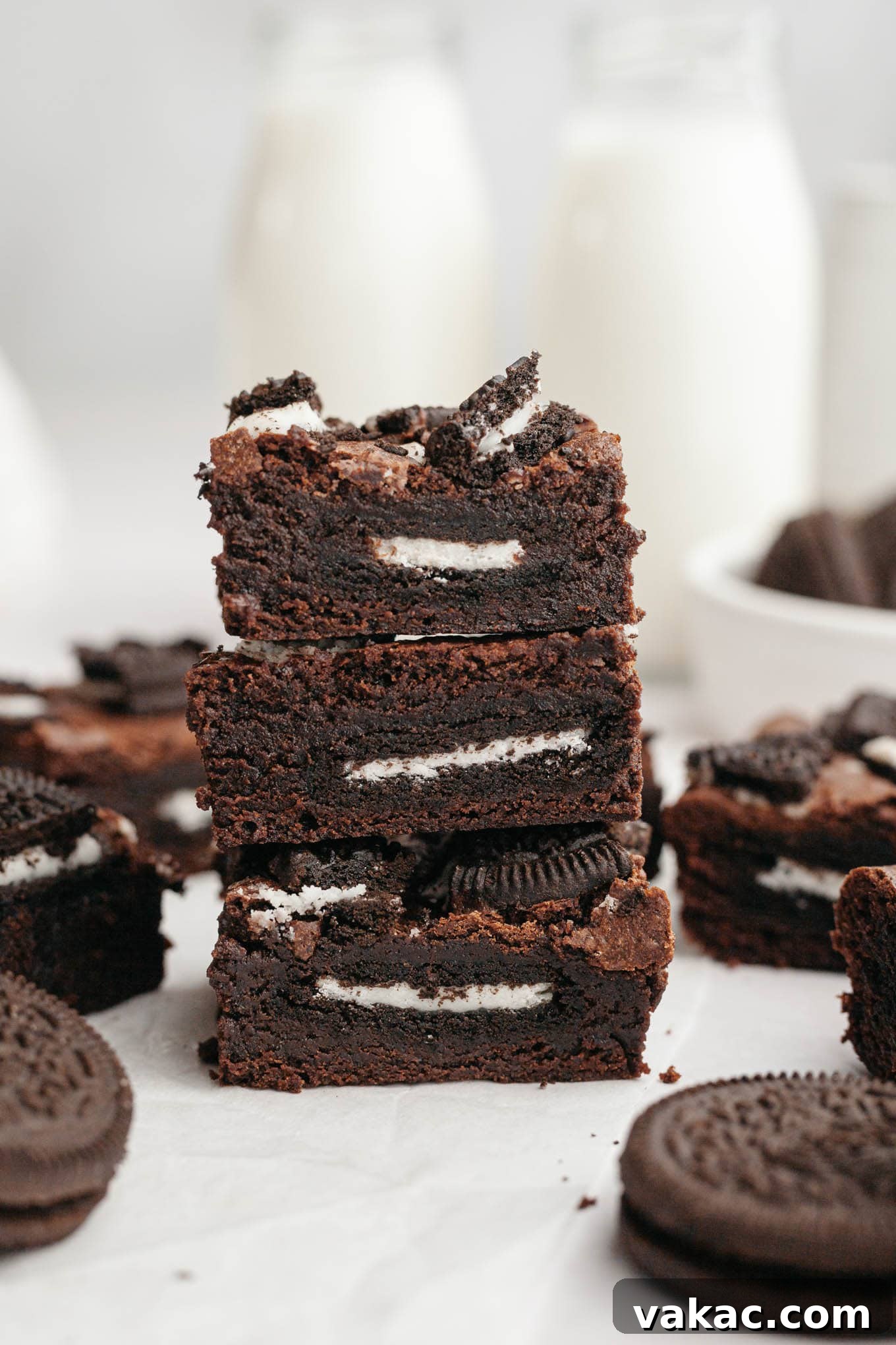 A delectable stack of three fudgy Oreo brownies, showcasing their rich chocolate interior, golden-brown crinkly top, and crushed Oreo topping.