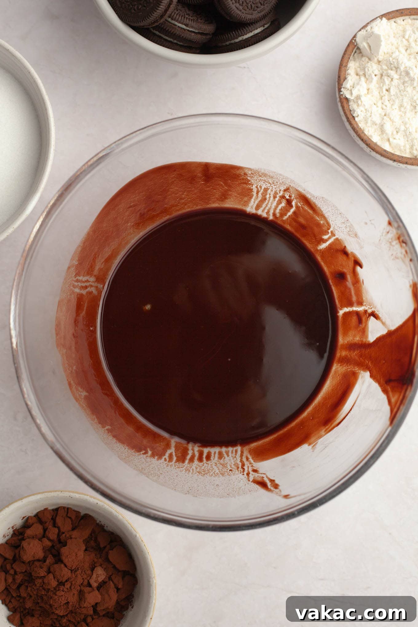 An overhead view of rich melted butter and finely chopped semi-sweet chocolate blending together beautifully in a mixing bowl, creating the decadent base for the brownie batter.