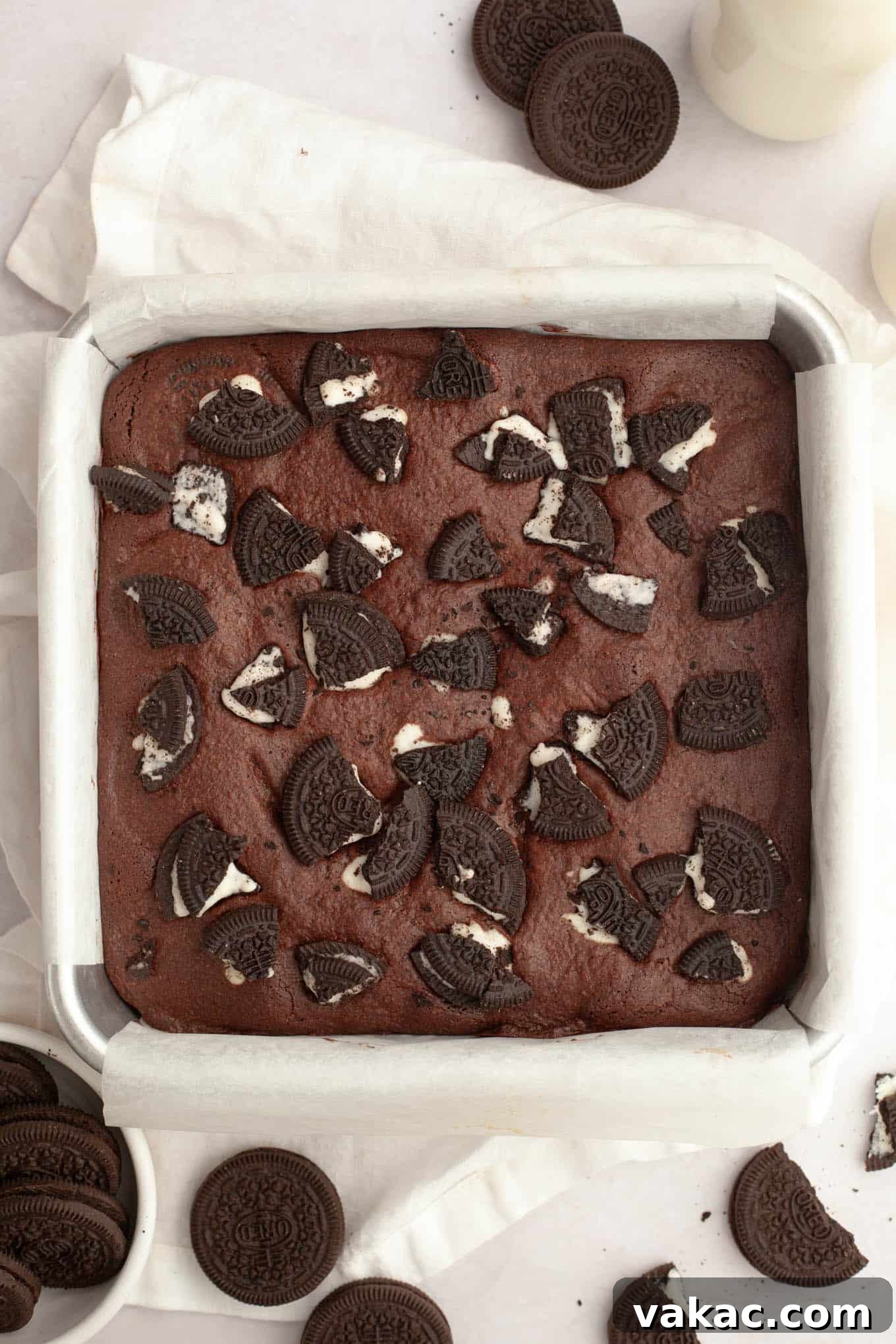 An overhead shot of freshly baked chocolate brownies, generously topped with an appealing scattering of crushed Oreos, cooling beautifully in their pan after being removed from the oven.