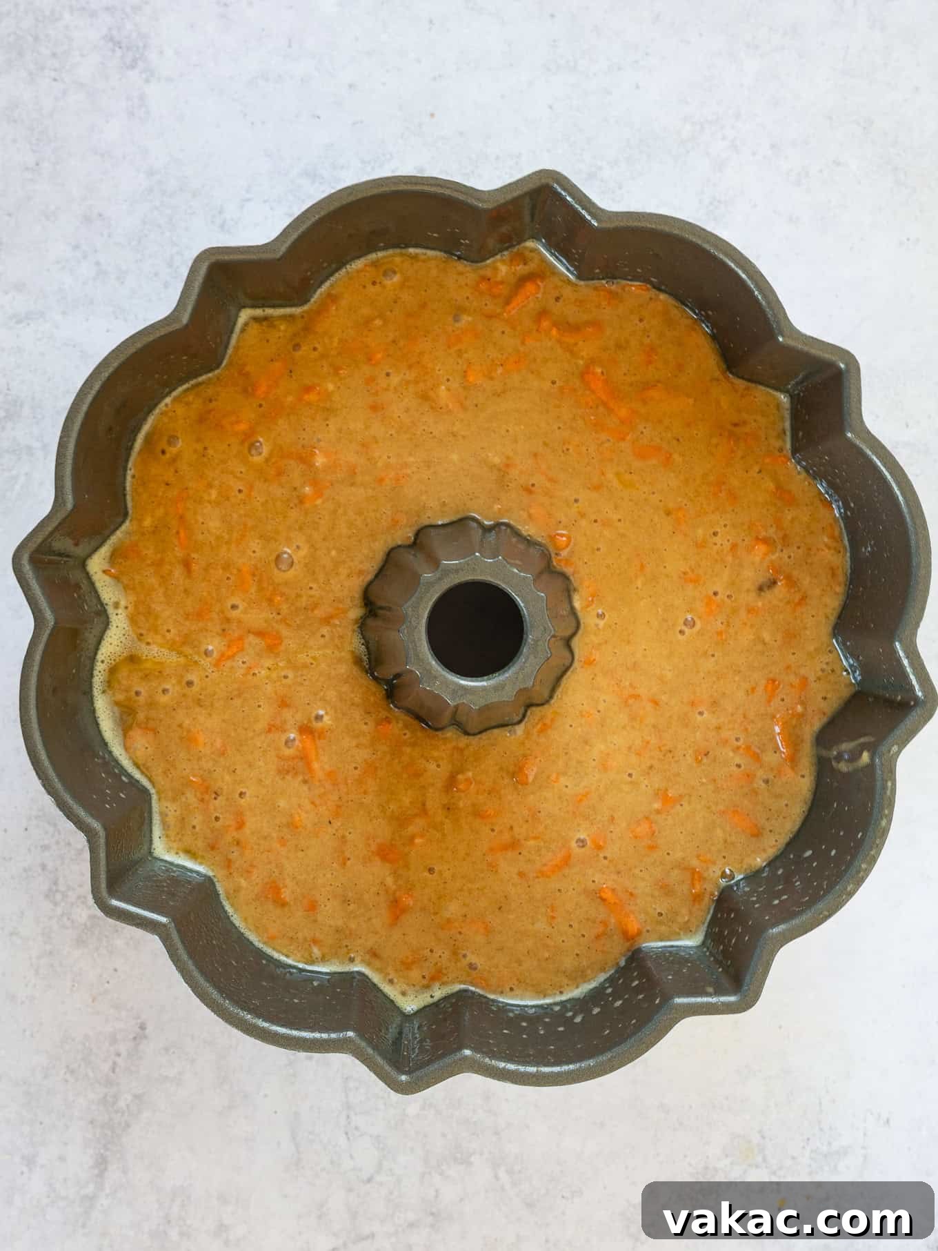 An overhead view of carrot cake batter expertly poured into a bundt pan, ready for baking.