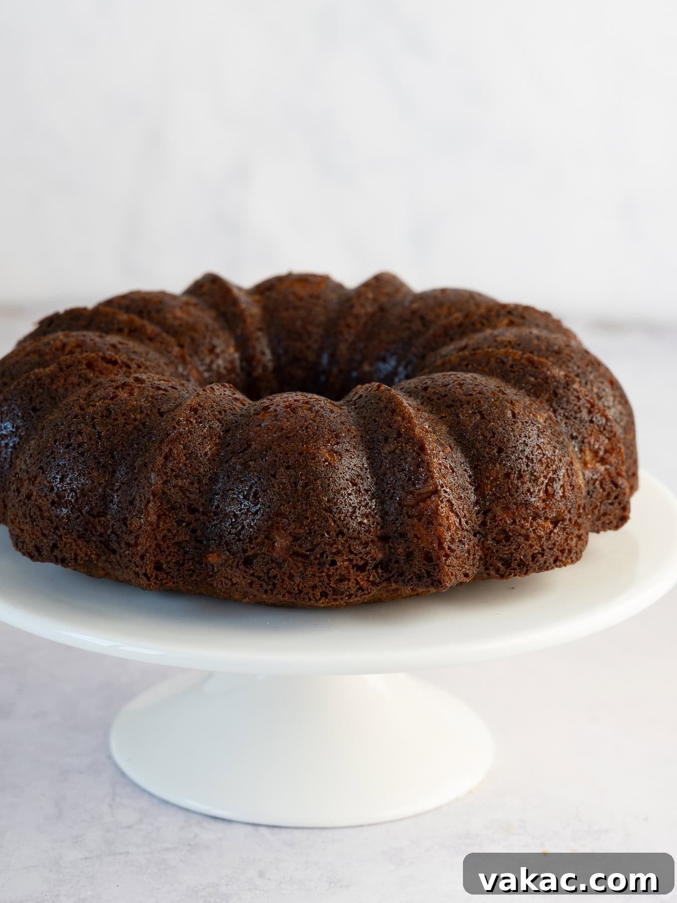 A perfectly baked, unfrosted carrot bundt cake resting elegantly on a cake stand.