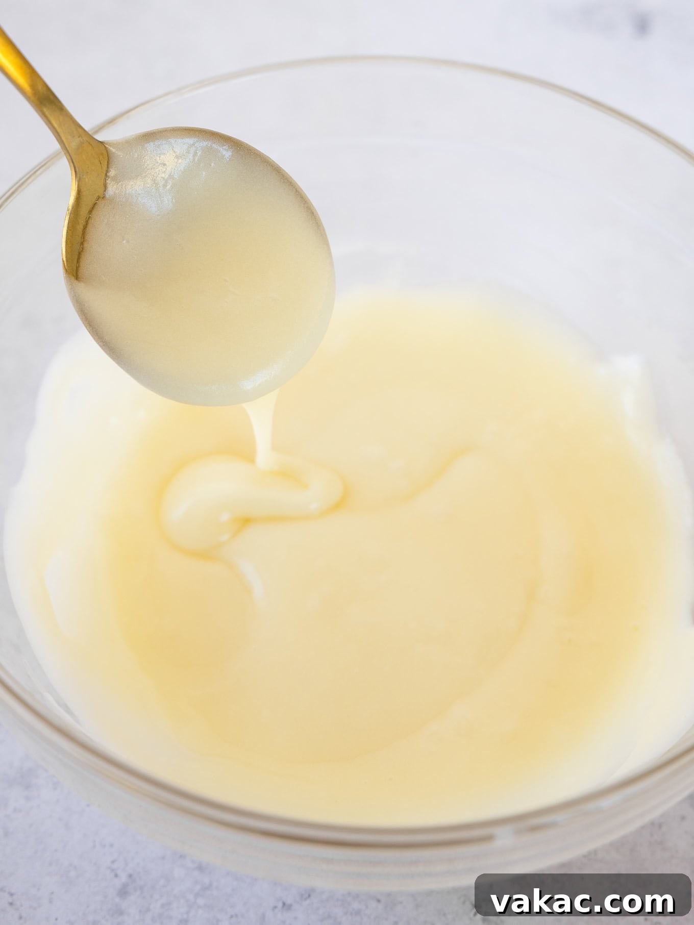 Smooth, creamy cream cheese icing in a bowl, ready to be poured.