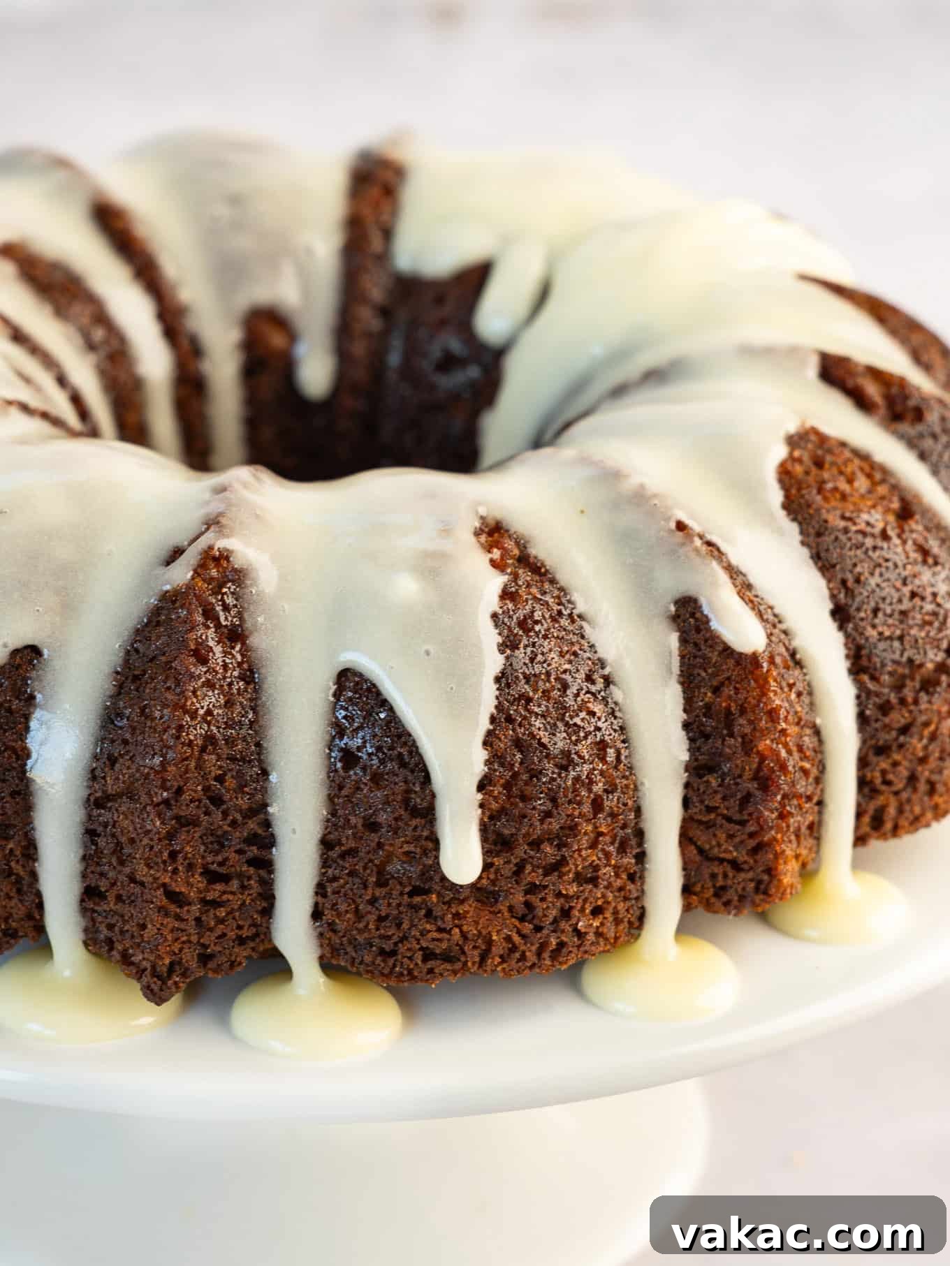 A carrot bundt cake elegantly drizzled with a generous amount of cream cheese icing.
