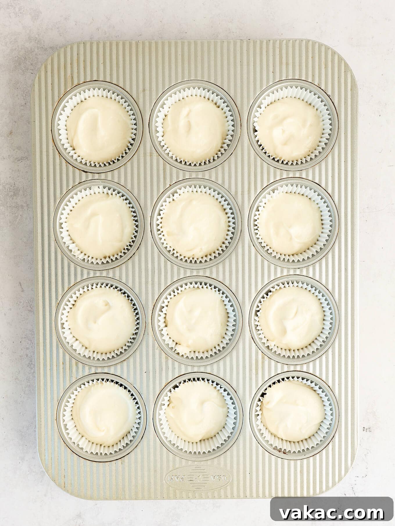 Fluffy White Cupcakes 8 Overhead view of cupcake liners filled evenly with white batter, ready for baking.