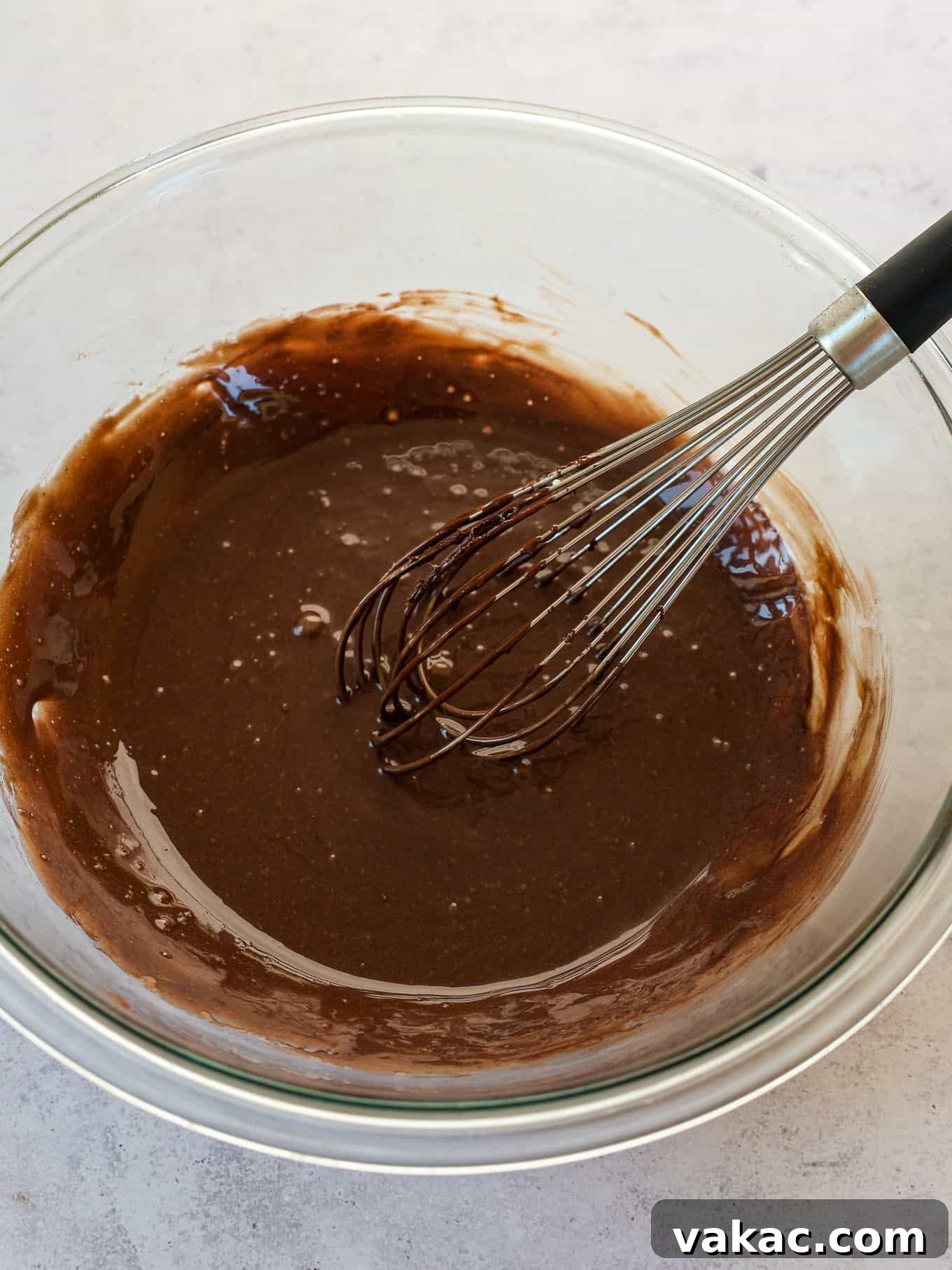 Decadent Chocolate Bliss 6 The melted chocolate mixture in a bowl with a whisk, showing its smooth and glossy texture.